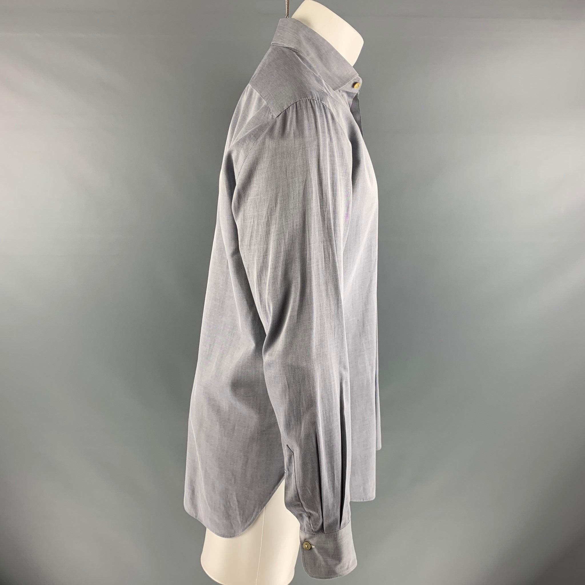 La chemise à manches longues KITON est en 100% coton gris. Elle présente un col rond et se ferme par un bouton.
Fabriqué en Italie. Très bon état. 

Marqué :   15 3/4 & 40 

Mesures : 
 
Épaule : 18 pouces Poitrine : 42 pouces Manches : 26 pouces