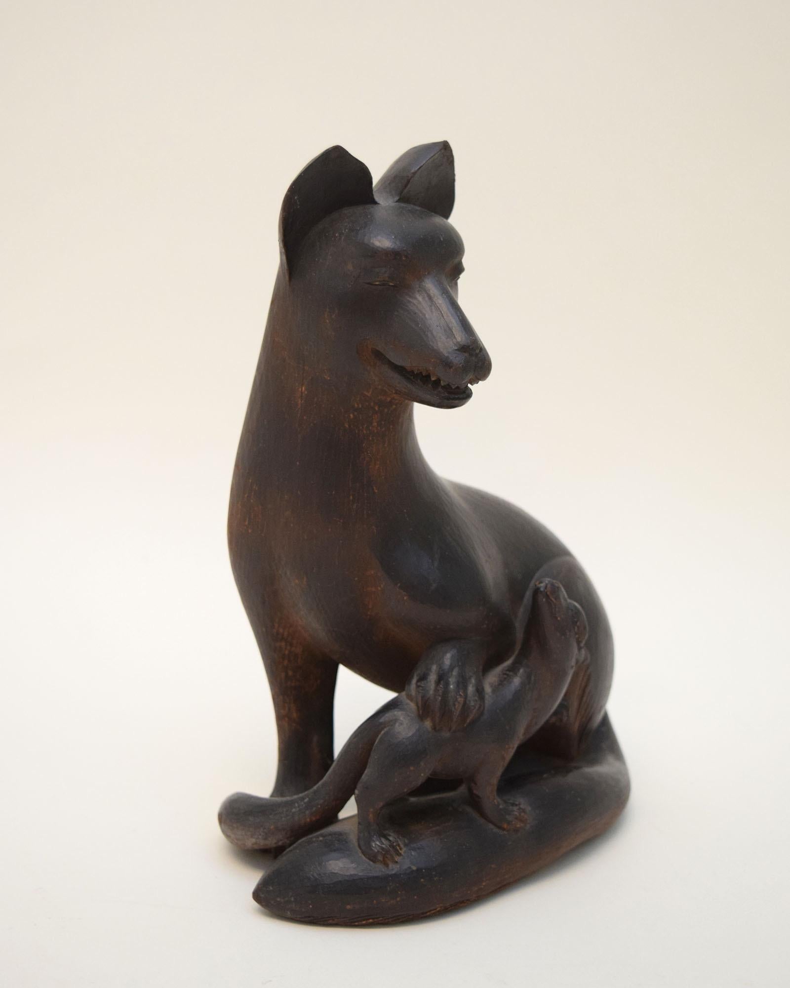 According to Japanese folklore the fox, or kitsune, can assume human form to protect and trick humble country folk. Dating to the 18th century, this fox protects its own pup. Carved and painted with a dull black lacquer finish called urushi, it’s