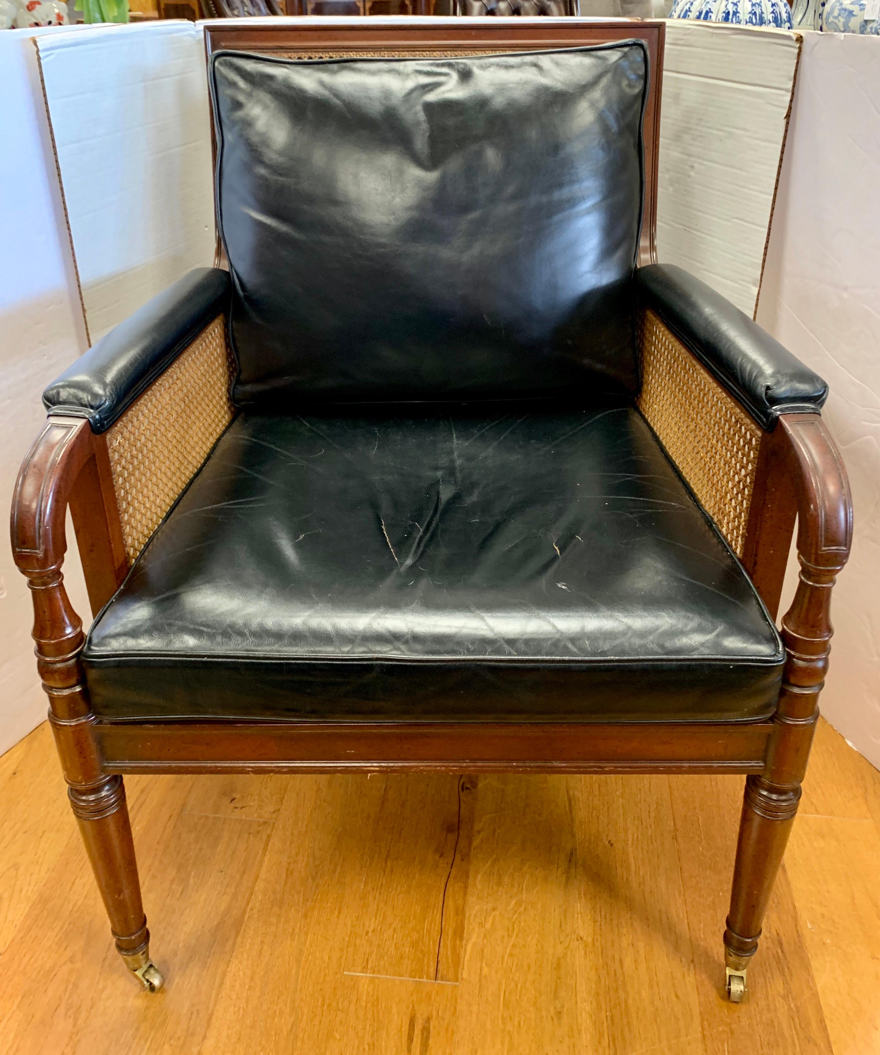 Vintage 1950s rare Kittinger Furniture black leather chair that features caning and caster wheels. Made in the USA and still in great condition, especially given its age. That said, the leather seat has some creasing which adds to its luster. The