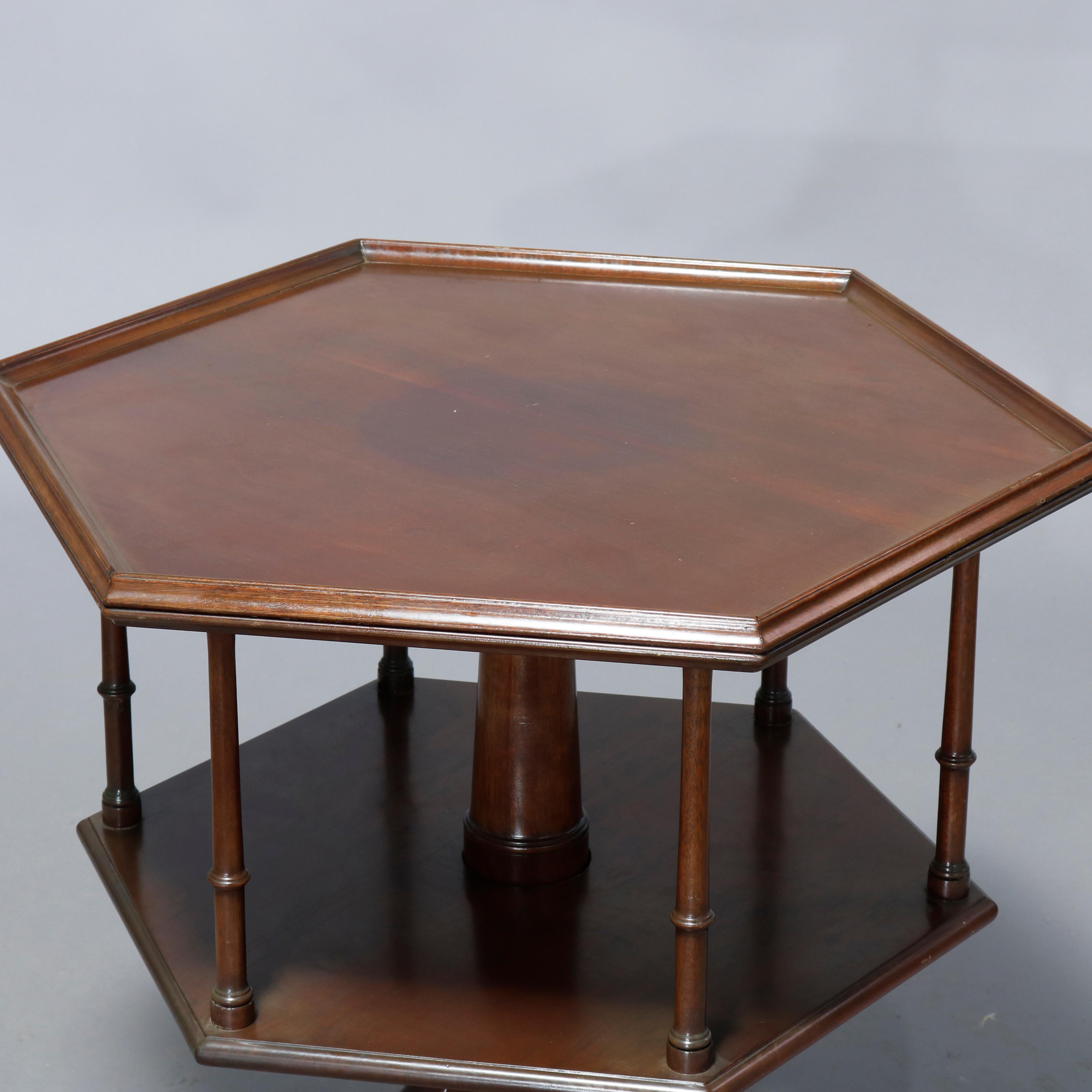 An antique Kittinger Colonial Williamsburg Queen Anne style revolving server offers mahogany construction in hexagonal form with upper and lower platforms having turned spindle supports and raised on turned tripod column with cabriole legs, maker