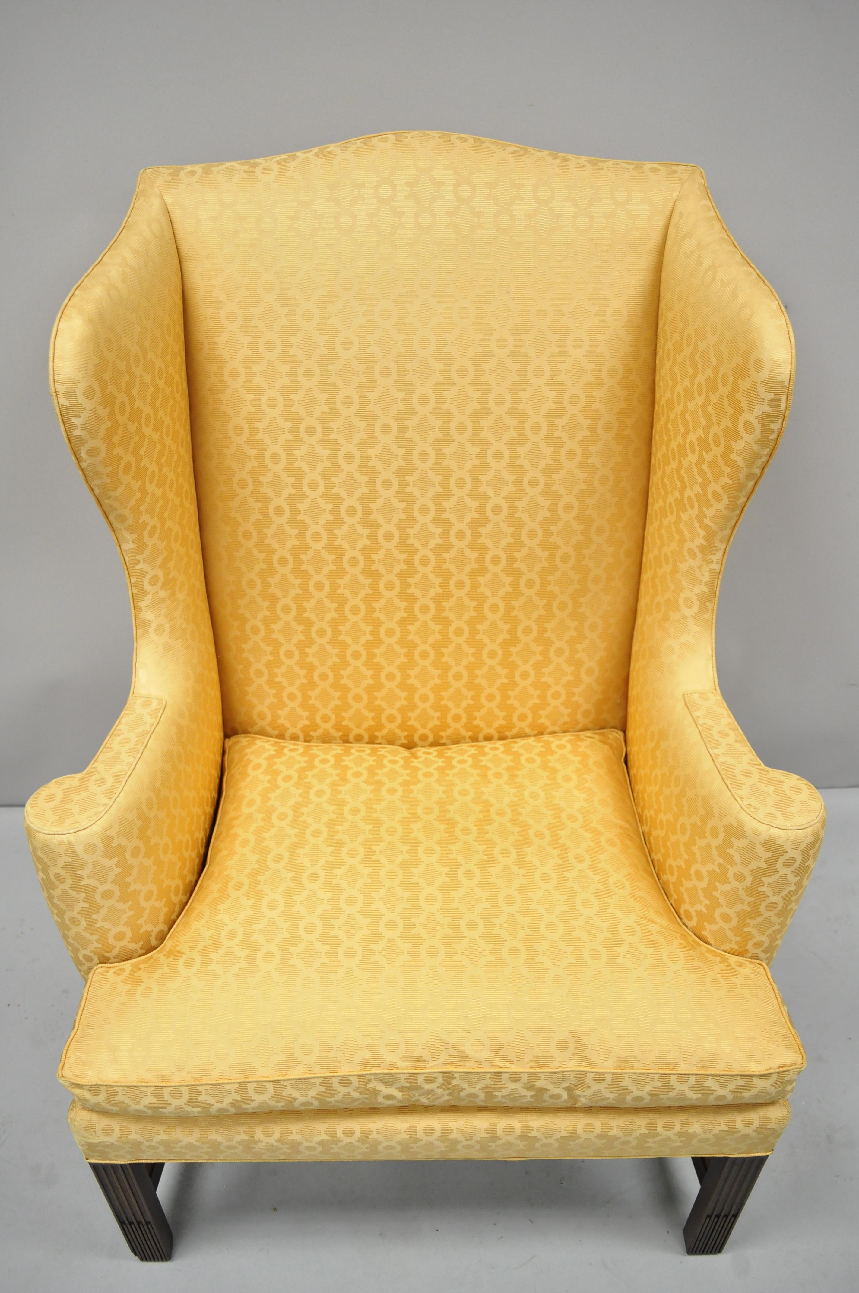 Kittinger CW-12 Colonial Williamsburg gold wing wingback mahogany chair. Item features rolled arms, wing back, original gold fabric, solid mahogany wood frame, nicely carved details, original labels, quality American craftsmanship, circa 1967.