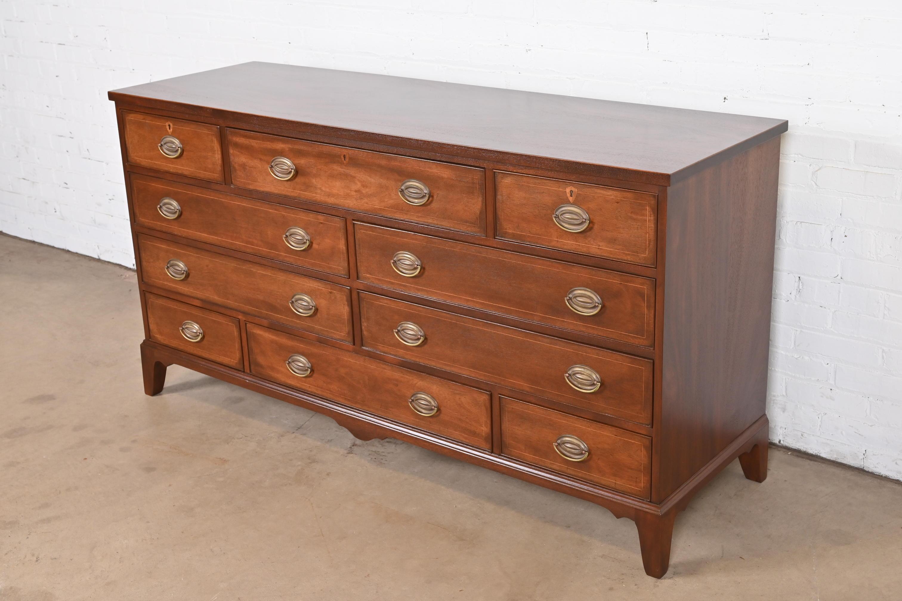 An exceptional Federal or Georgian style ten-drawer dresser or chest of drawers

By Kittinger

USA, Circa 1960s

Gorgeous mahogany, with satinwood inlay, and original brass hardware.

Measures: 66