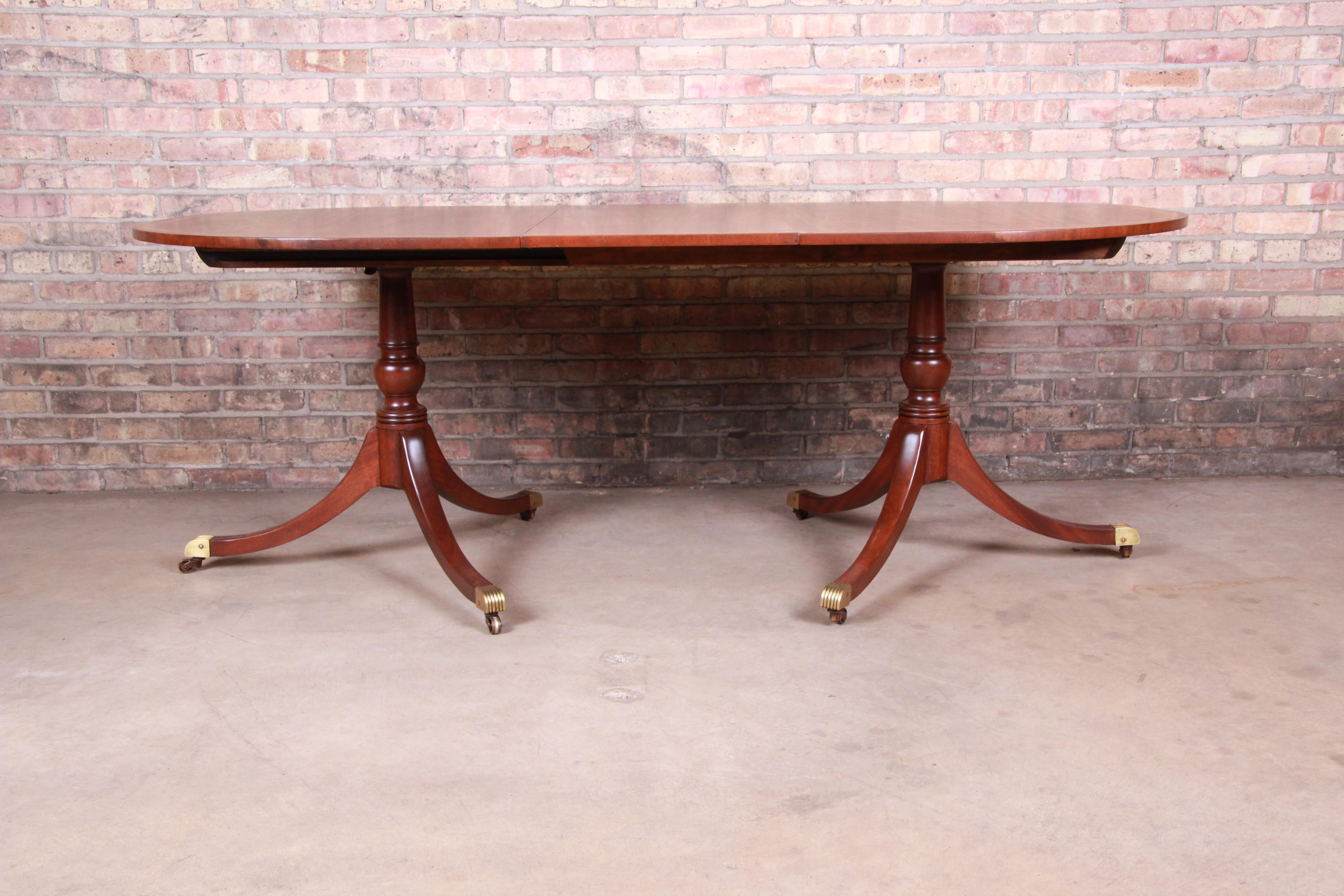 An exceptional Georgian banded mahogany double pedestal extension dining table

By Kittinger Furniture

USA, circa 1940s

Book-matched mahogany with banded edge and brass-capped feet and casters.

Measures: 60