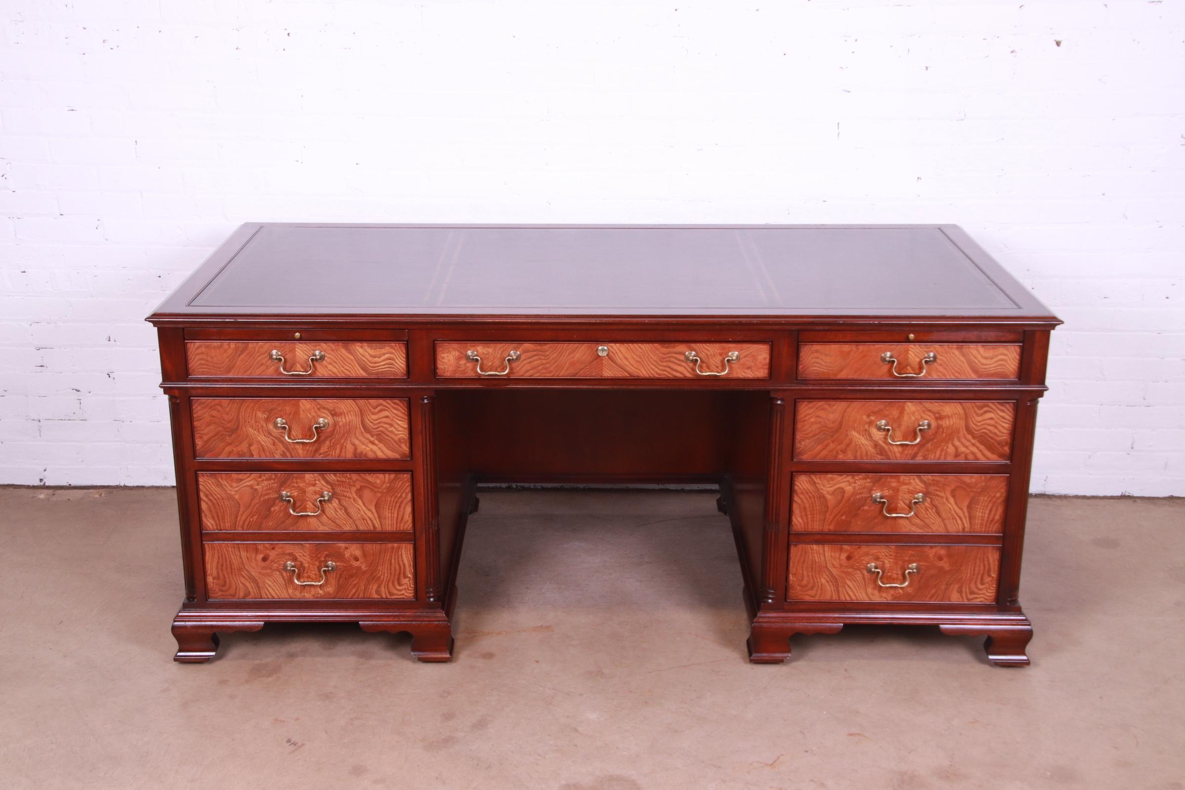 A stately Georgian or Chippendale style executive desk with inlaid leather top

By Kittinger Furniture

USA, mid-20th century

Gorgeous burl wood, with carved mahogany, original brass pulls and inlaid embossed leather top.

Measures: 72