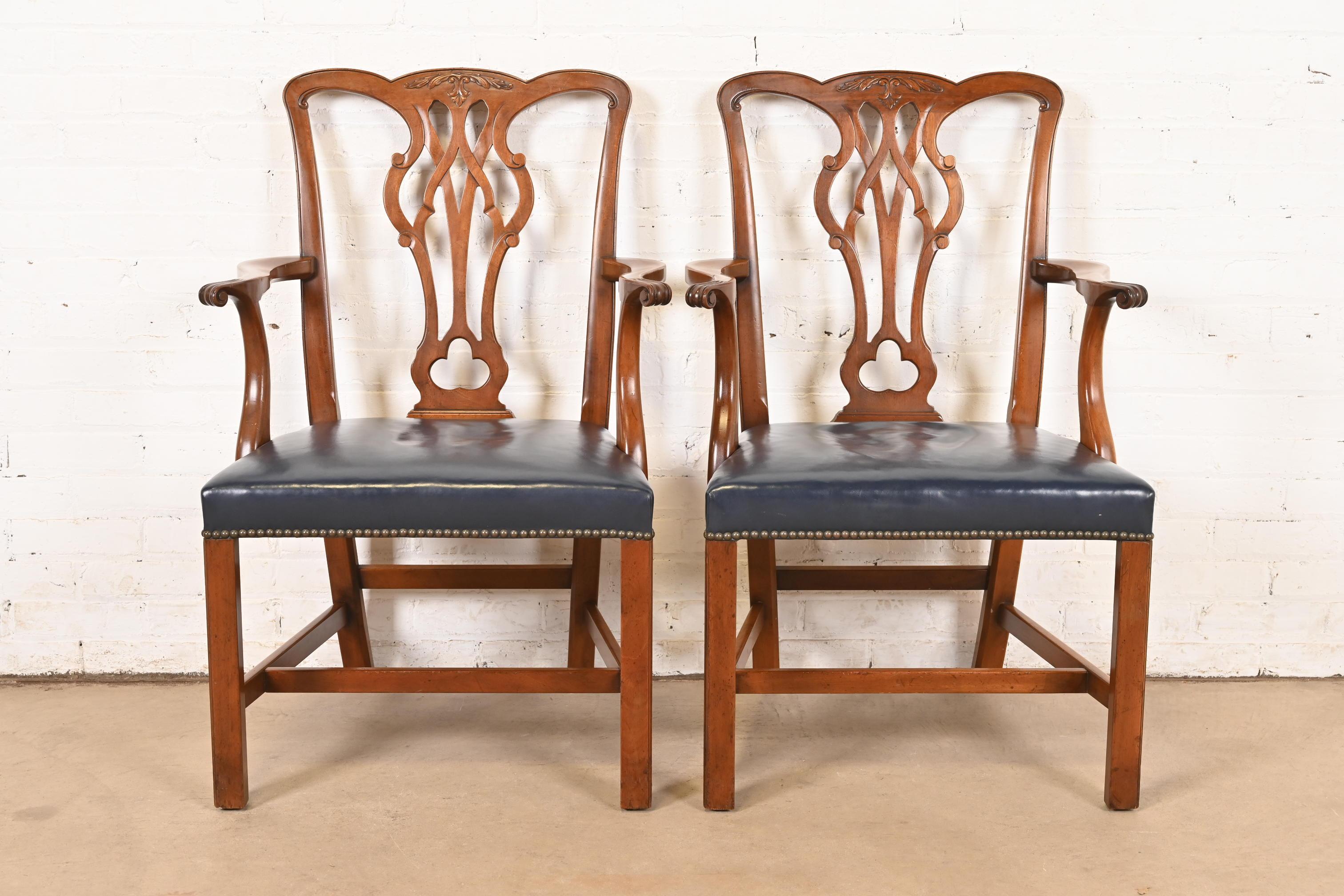 Una splendida coppia di poltrone o sedie da capitano in stile georgiano o Chippendale

Da Kittinger

USA, circa anni '1980

Mogano intagliato, con sedili in pelle blu tempestati di ottone.

Misure: 24,5