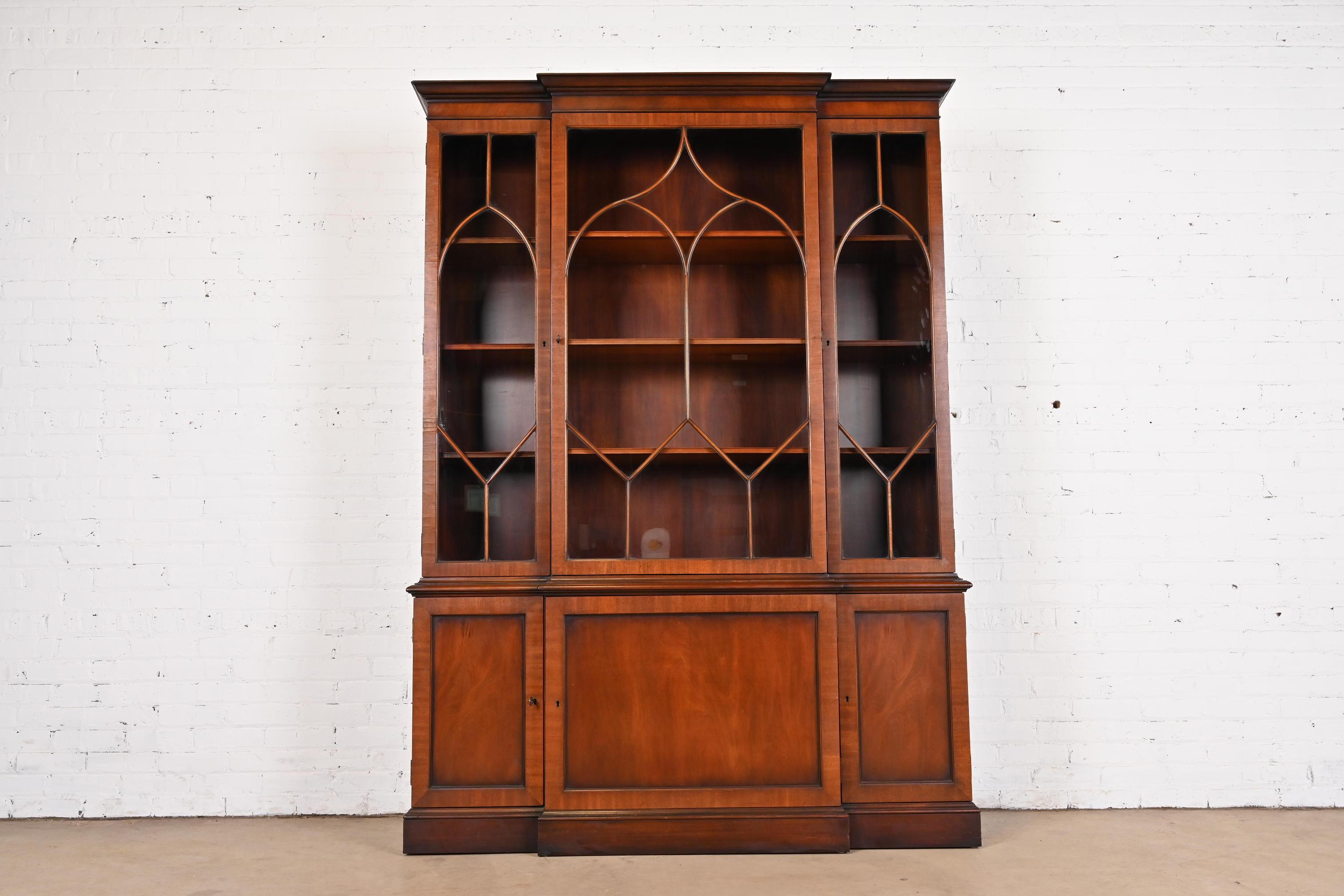 A gorgeous Georgian or Chippendale style breakfront bookcase or dining cabinet

By Kittinger

USA, Circa 1960s

Carved mahogany, with mullioned glass front doors. Cabinet locks, and key is included.

Measures: 59.5