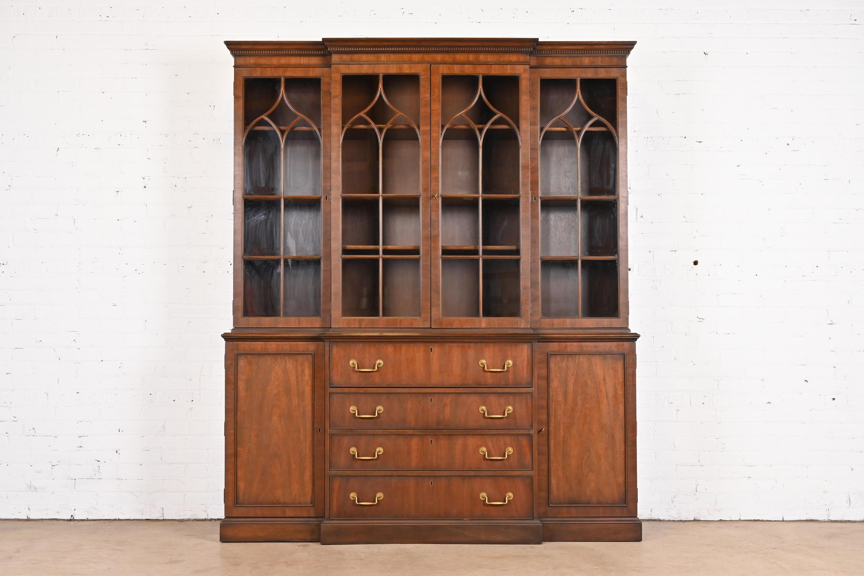 A gorgeous Georgian or Chippendale style breakfront bookcase or dining cabinet with drop front secretary desk

By Kittinger

USA, Circa 1960s

Carved mahogany, with mullioned glass front doors and original brass hardware. Cabinet locks, and key is