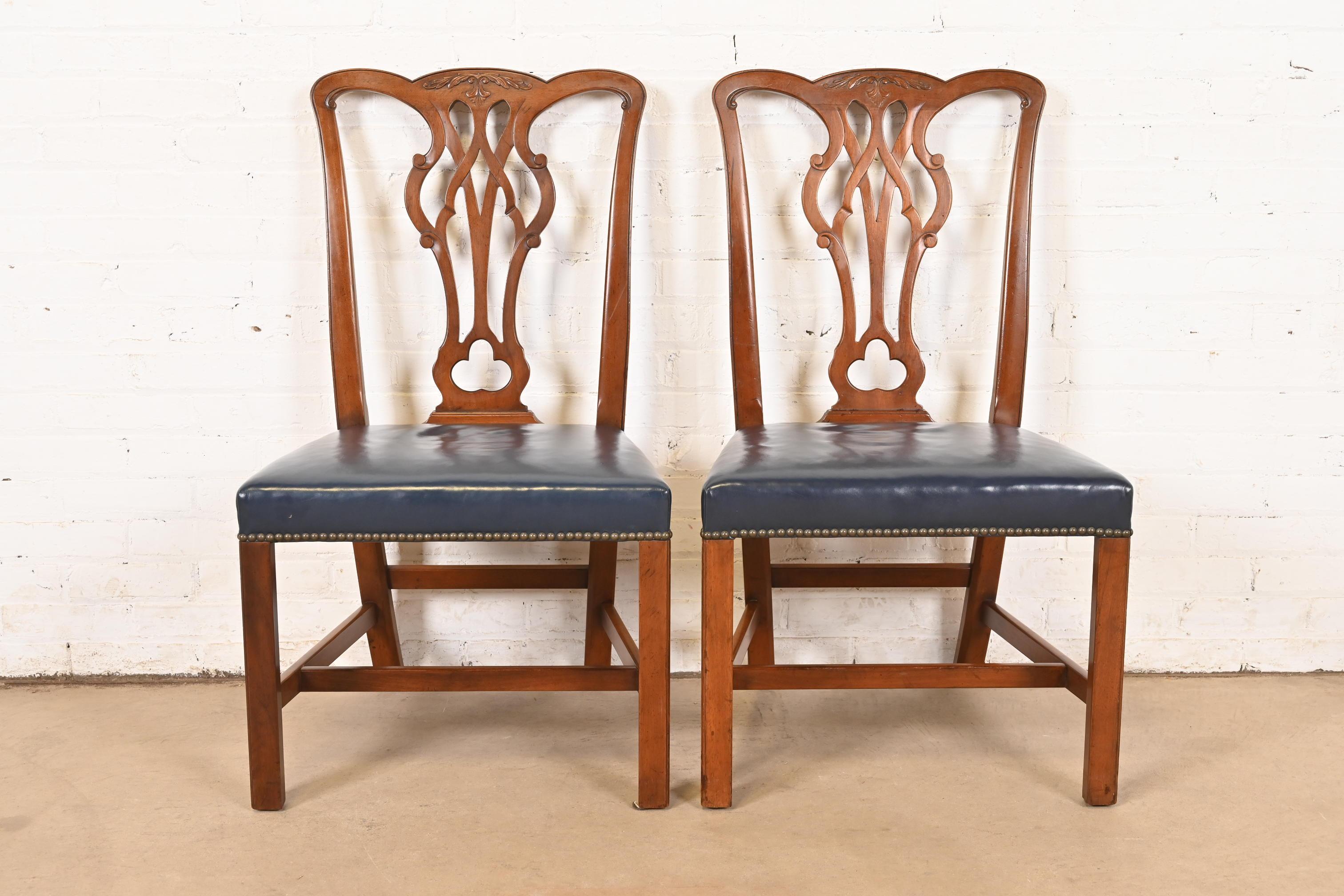 A gorgeous pair of Georgian or Chippendale style side chairs or dining chairs

By Kittinger

USA, Circa 1980s

Carved mahogany, with brass studded blue leather seats.

Measures: 22