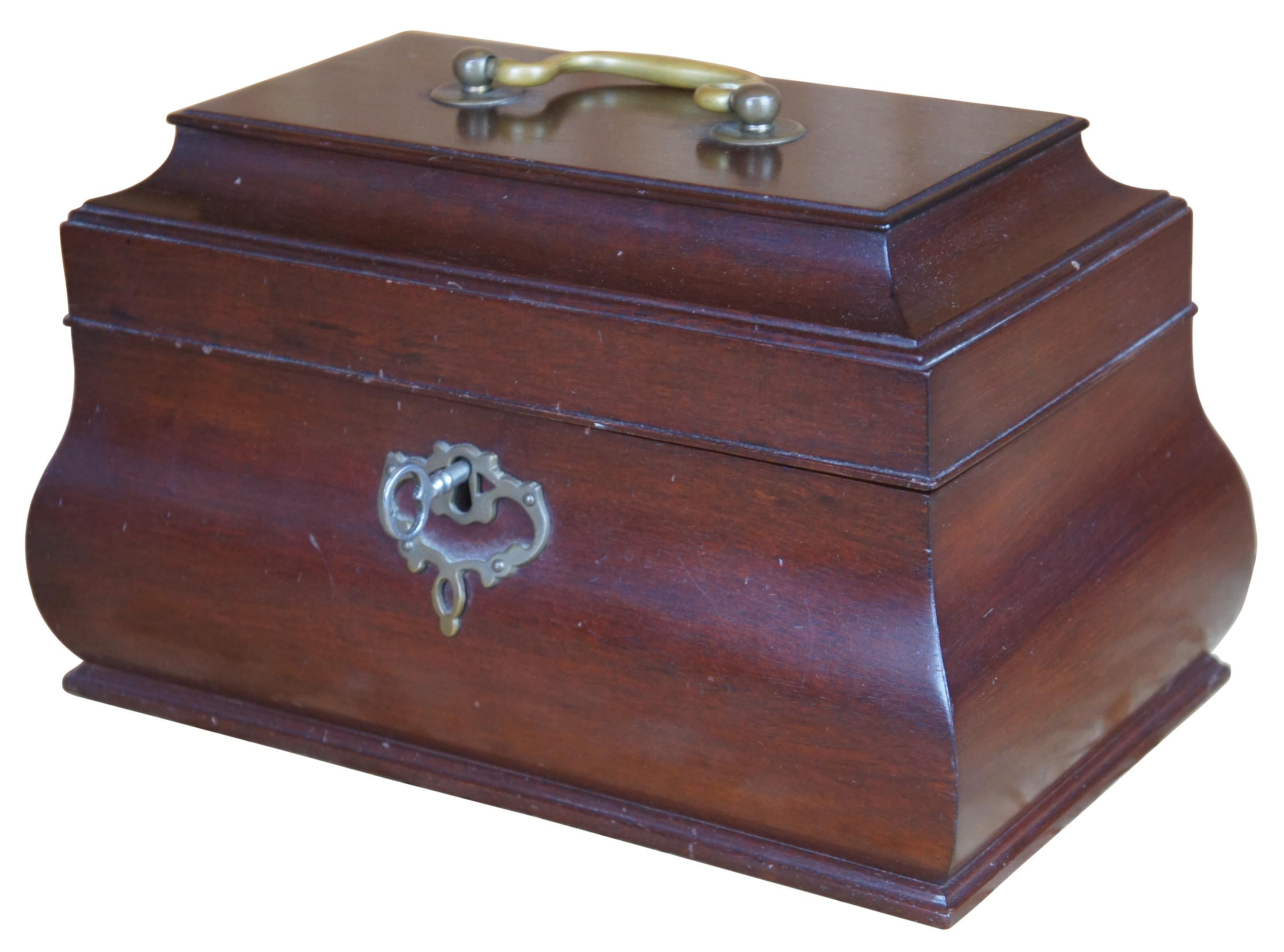 Kittinger solid mahogany tea caddy in bombe form from the Colonial Williamsburg Collection. Features brass handle and escutcheon, fitted interior. Includes key. Marked along underside.
      