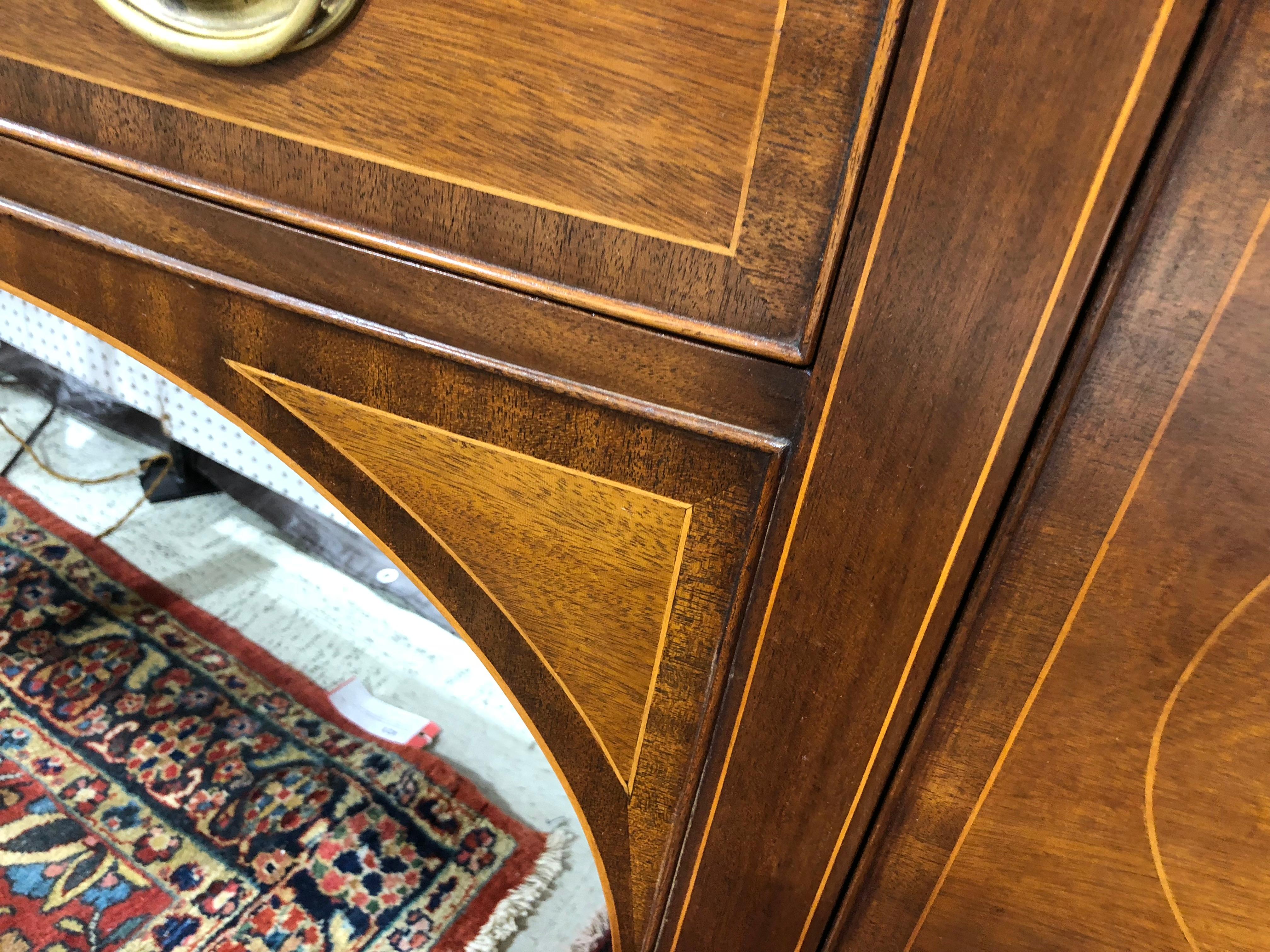 Georgian style sideboard in mahogany with satinwood inlays, circle line inlays, and edging on the top. Serpentine shape, tall and leggy, great size, excellent color, original pulls. A very traditional look in a pure Georgian style.
