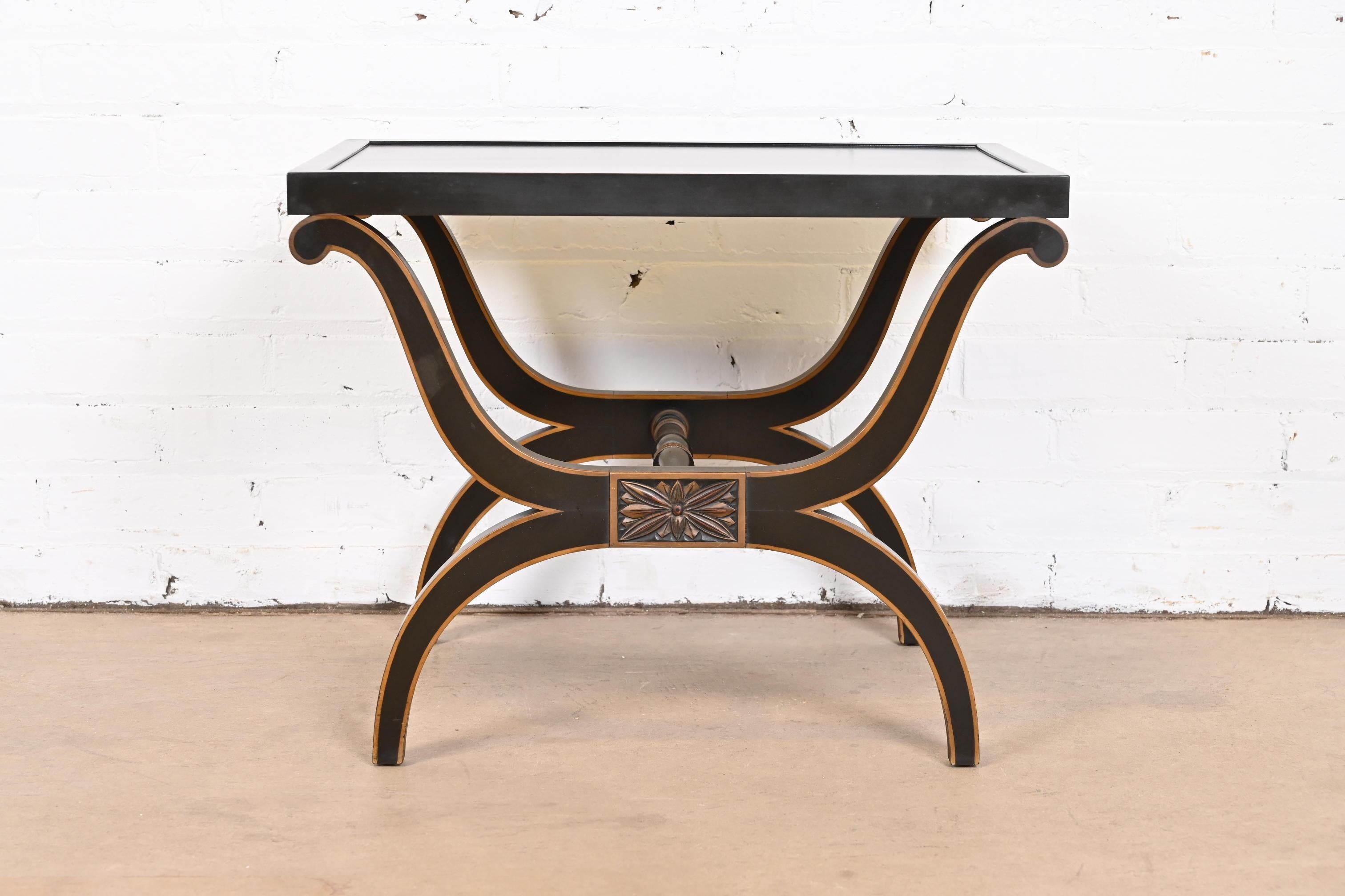 A gorgeous Neoclassical or Empire style Curule ebonized and parcel gilt tea table or occasional side table

By Kittinger

USA, Mid 20th Century

Measures: 22.5