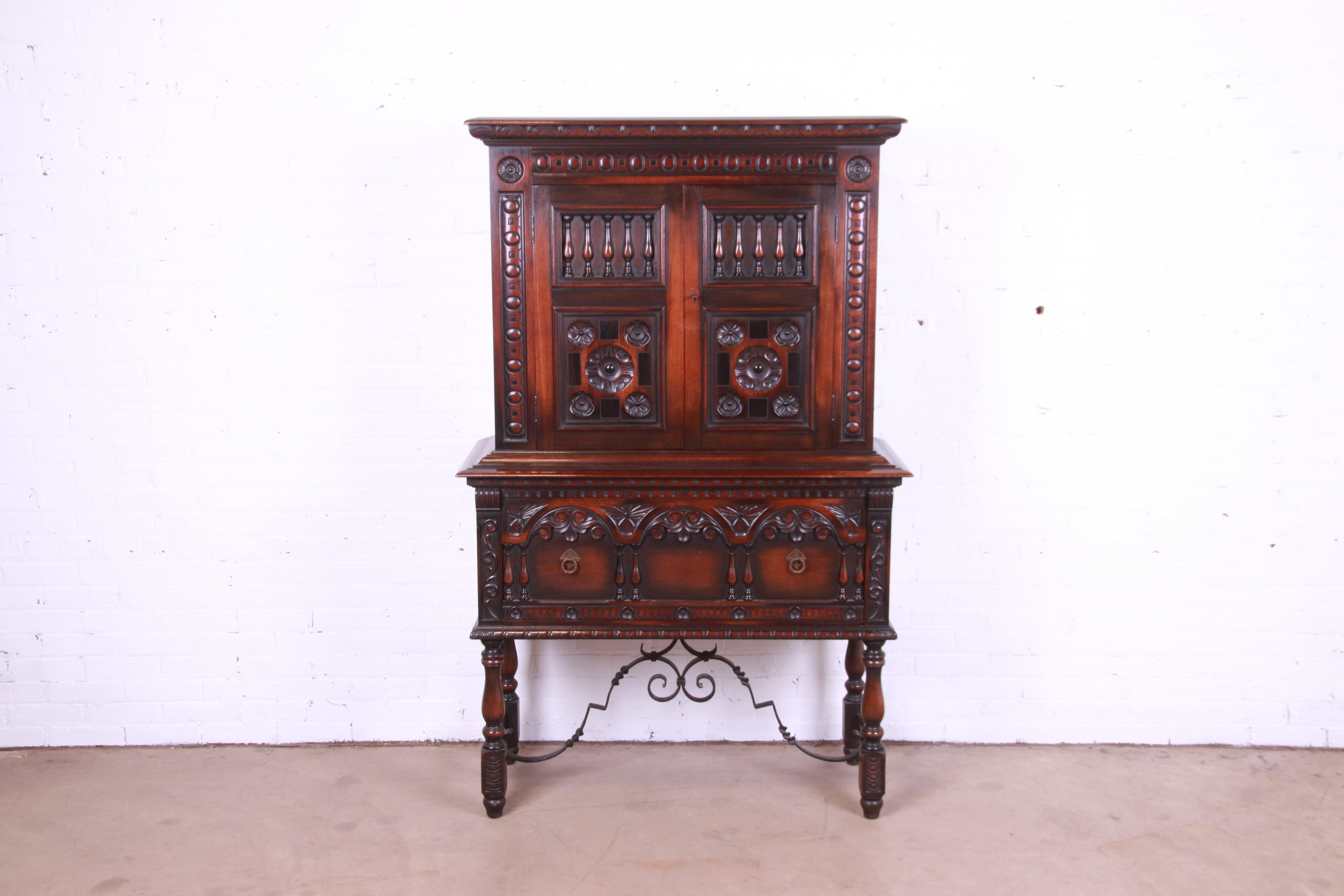 An exceptional Spanish Baroque style hutch or bar cabinet

By Kittinger

USA, Circa 1920s

Ornate carved walnut, with wrought iron stretchers and original brass hardware.

Measures: 43.38