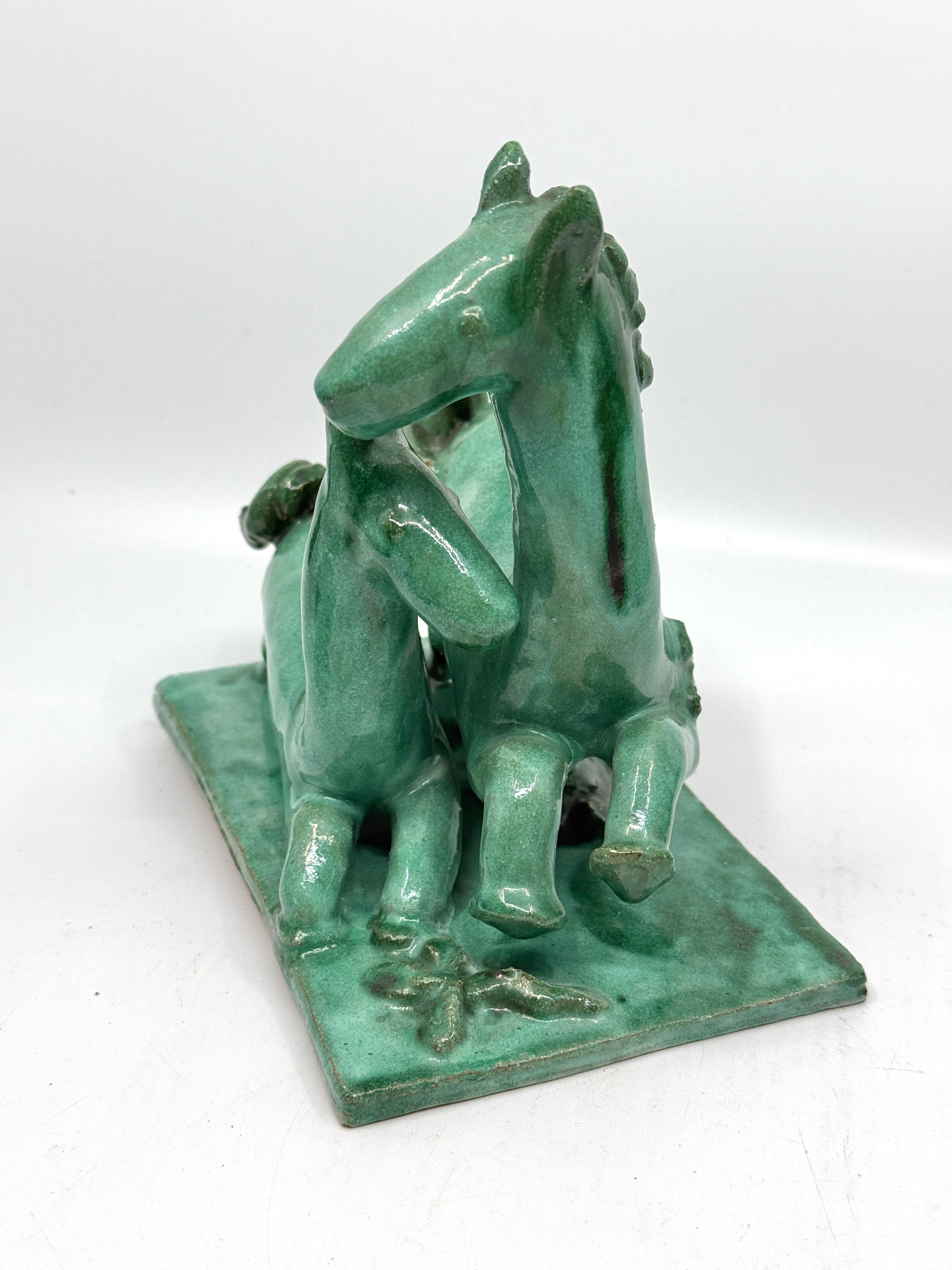 A wonderful whimsical terracotta group of a mother horse and her foal by the Austrian Master Kitty Rix Tihacek. It is well marked and monogrammed on the base. It is impressed with the  Wiener Werkstatte logo, Made in Austria, 312, and KR. 
It is in