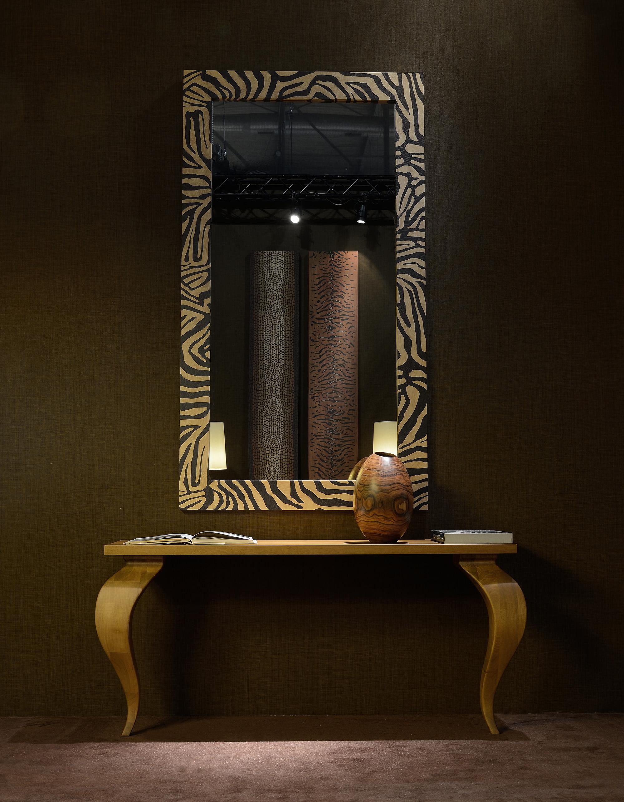 Der Rahmen dieses Spiegels ist aus Massivholz gefertigt und mit einer auffälligen Zebrastreifeneinlage versehen, die Ihrem Wohnbereich einen Hauch von Wildheit verleiht. Das Zebra-Finish hebt das filigrane Muster hervor und schafft ein Statement,