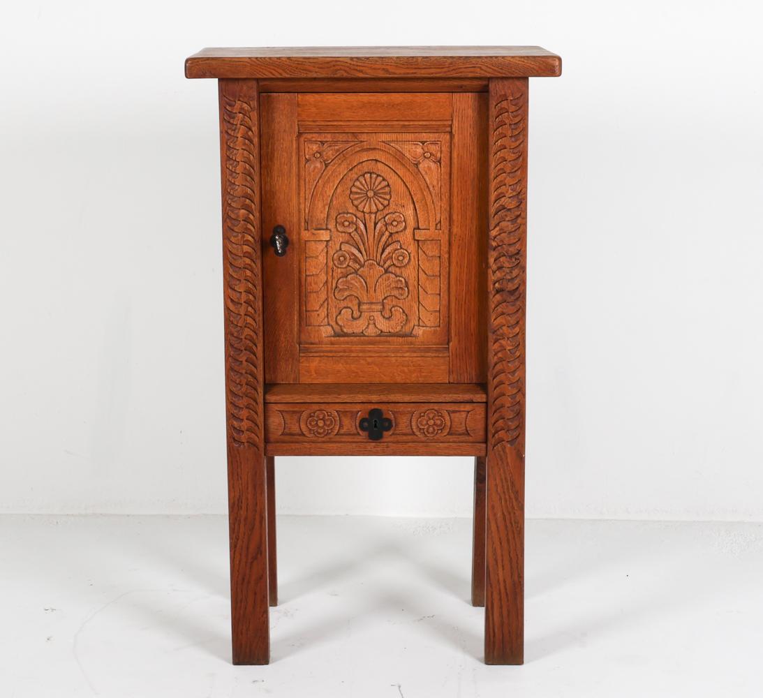 This diminutive oak sideboard has been carved in the Brutalist style with tones of the Gothic variety. With a design not unfamiliar to the famous Henry Kjaernulf, this piece has intricate carvings on the front door and legs, making it a work of art