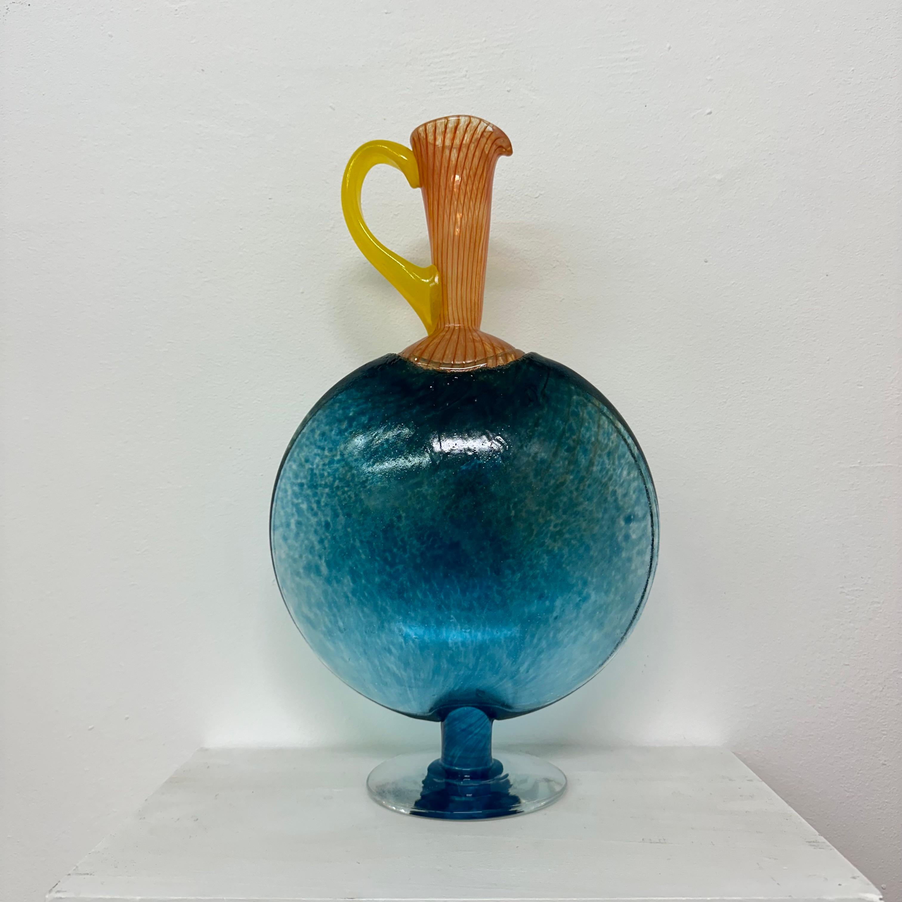 Brocca Kjell Engman per Kosta Boda , anni '80

Dimensioni: 35 cm di altezza, 20 cm di larghezza, 10,5 cm di profondità
Condizioni: Buono
Materiale: Vetro
Colore: blu, arancione, giallo