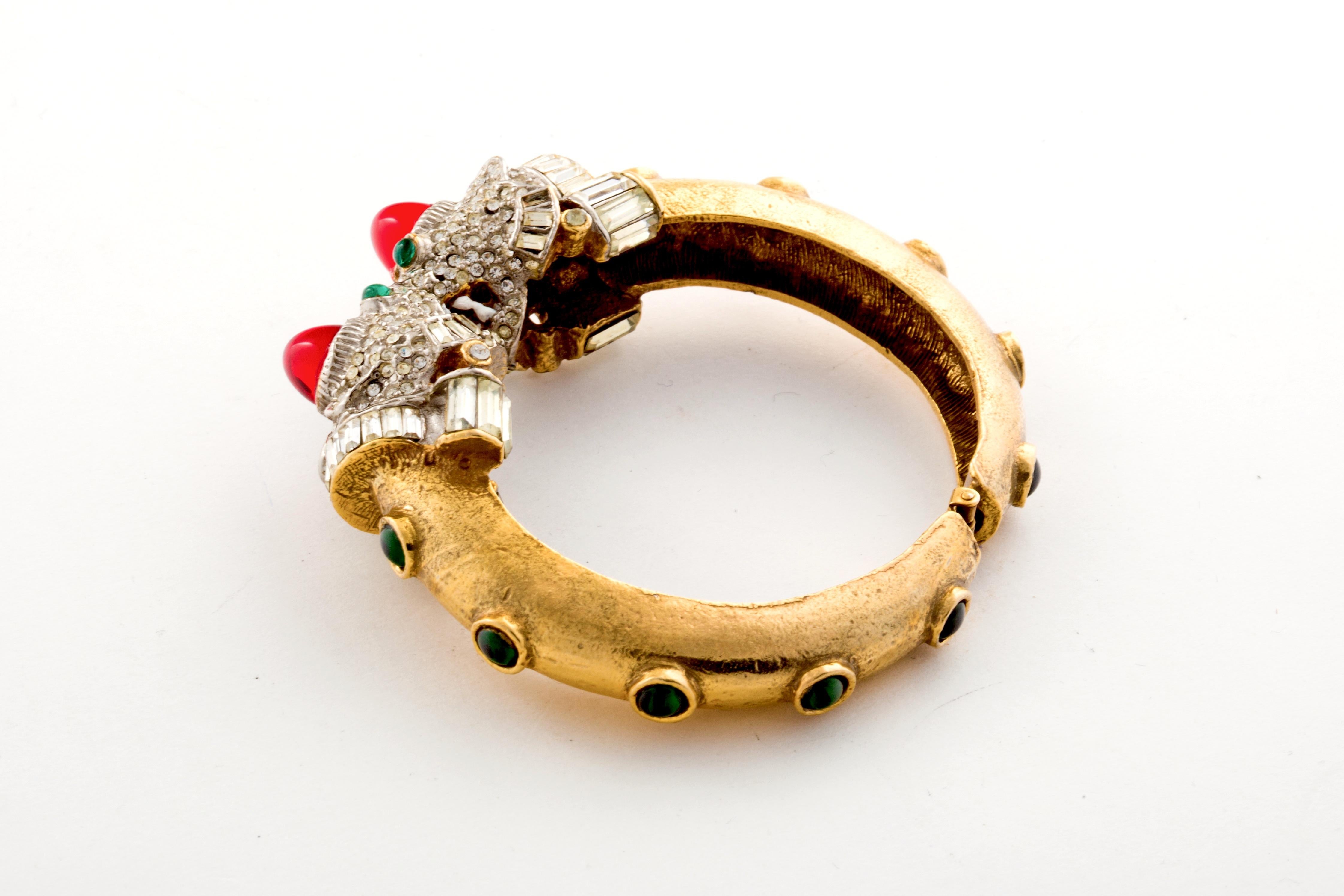 60's Kenneth J. Lane or KJL Foo Dog Bangle with a lot of fabulousness going on!  Cabochons, Emeralds and Rhinestones including both pave and a baguette cut collar on the dog!  Dark Green cabochon stones circle the bangle while his fangs and tongue