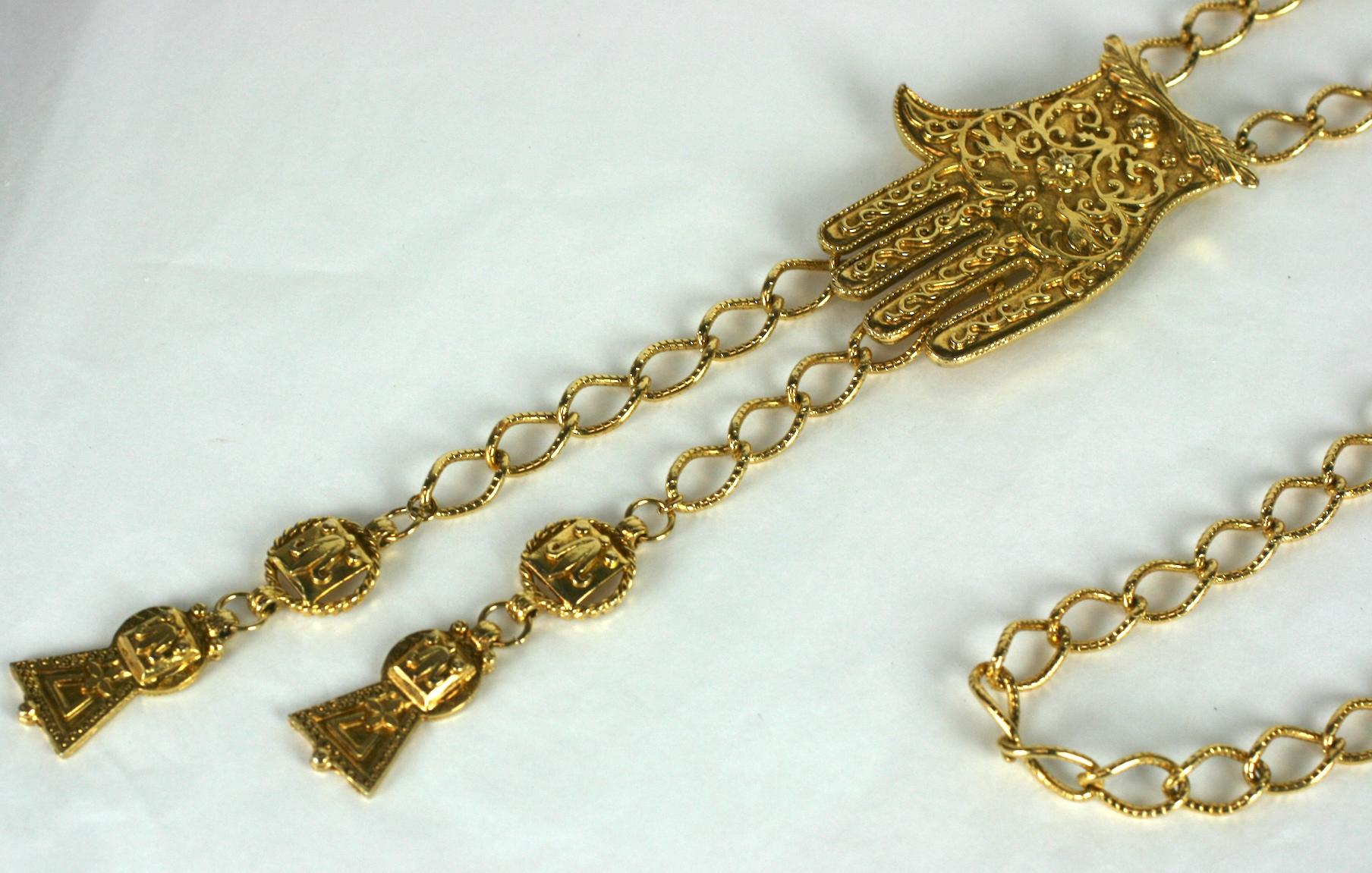 K.J.A. Collier/ceinture Hamsa en métal doré avec chaîne réglable et glands dorés. Le symbole Hamsa est orné de motifs filigranes. Signé KJL. 
Excellent état. 46