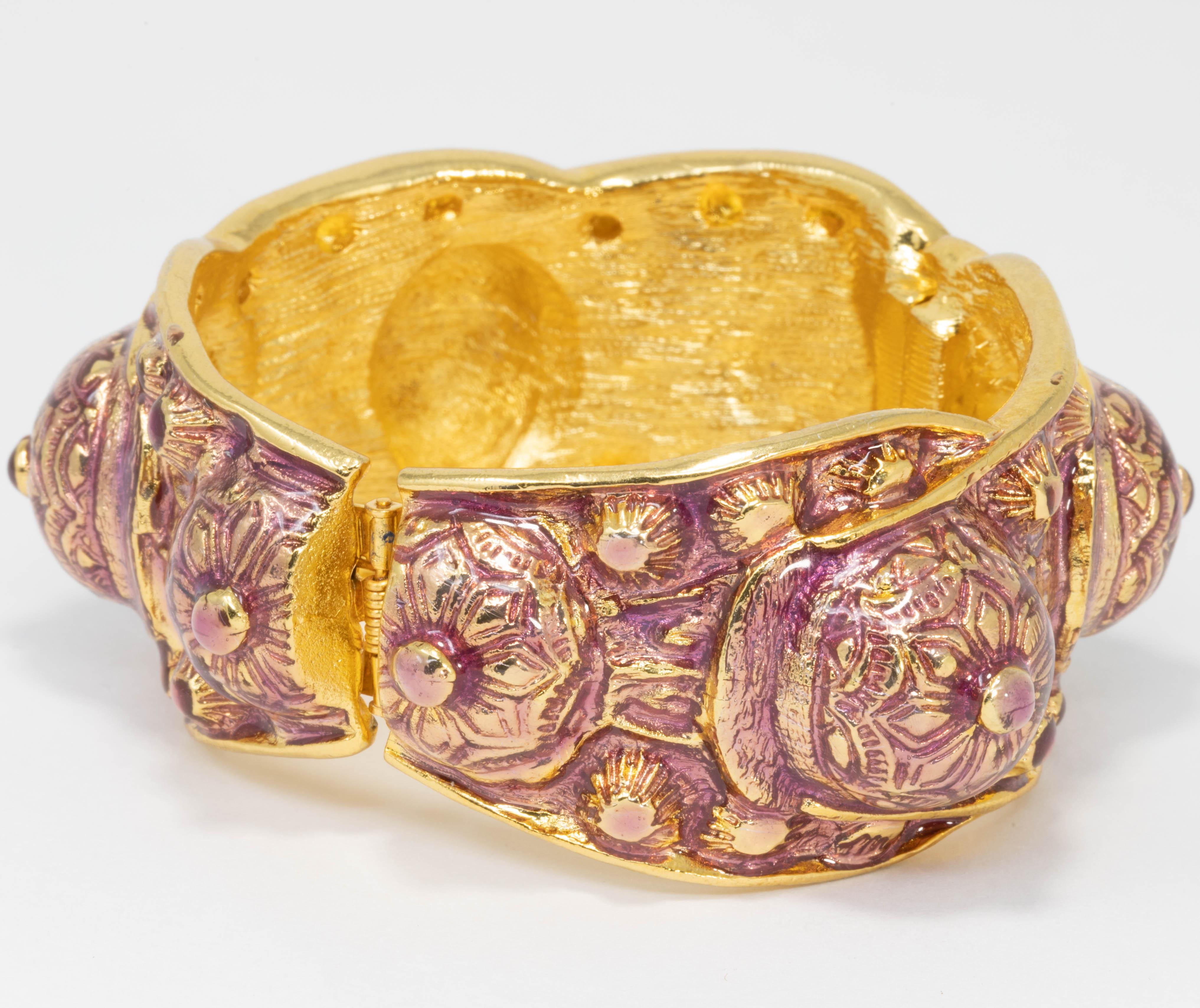 Ce bracelet élégant de Kenneth Jay Lane présente un motif complexe en relief peint avec de l'émail violet sur du métal plaqué or.

Poinçons : Kenneth Lane, fabriqué aux États-Unis

Circonférence intérieure : 6.5 in / 16,5 cm
Diamètre intérieur à la