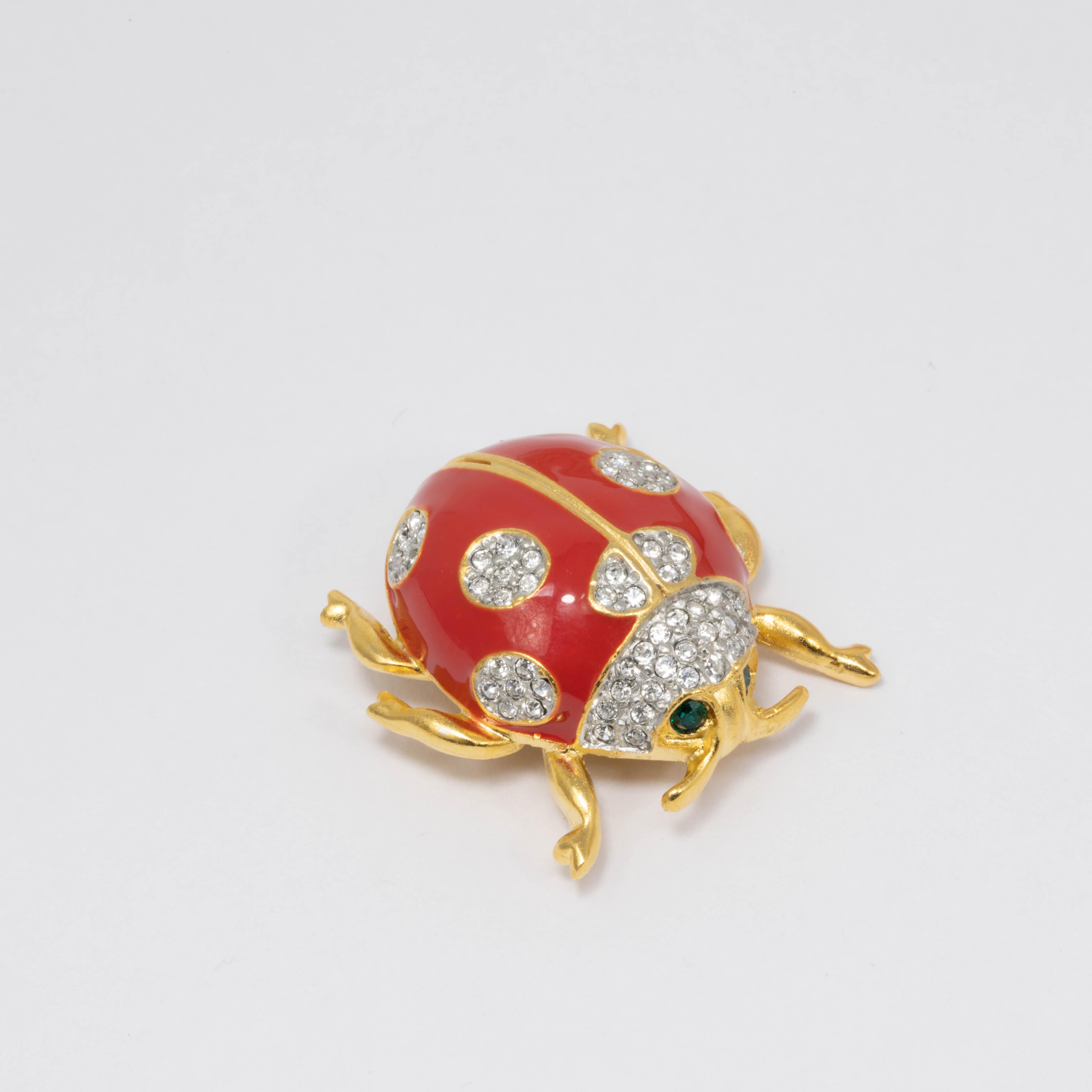 Ladybug pin brooch by Kenneth Jay Lane. This colorful critter features a golden body with crystal accents and painted red and black enamel.

Gold plated.

Tags, Marks, Hallmarks: Kenneth © Lane, Made in USA