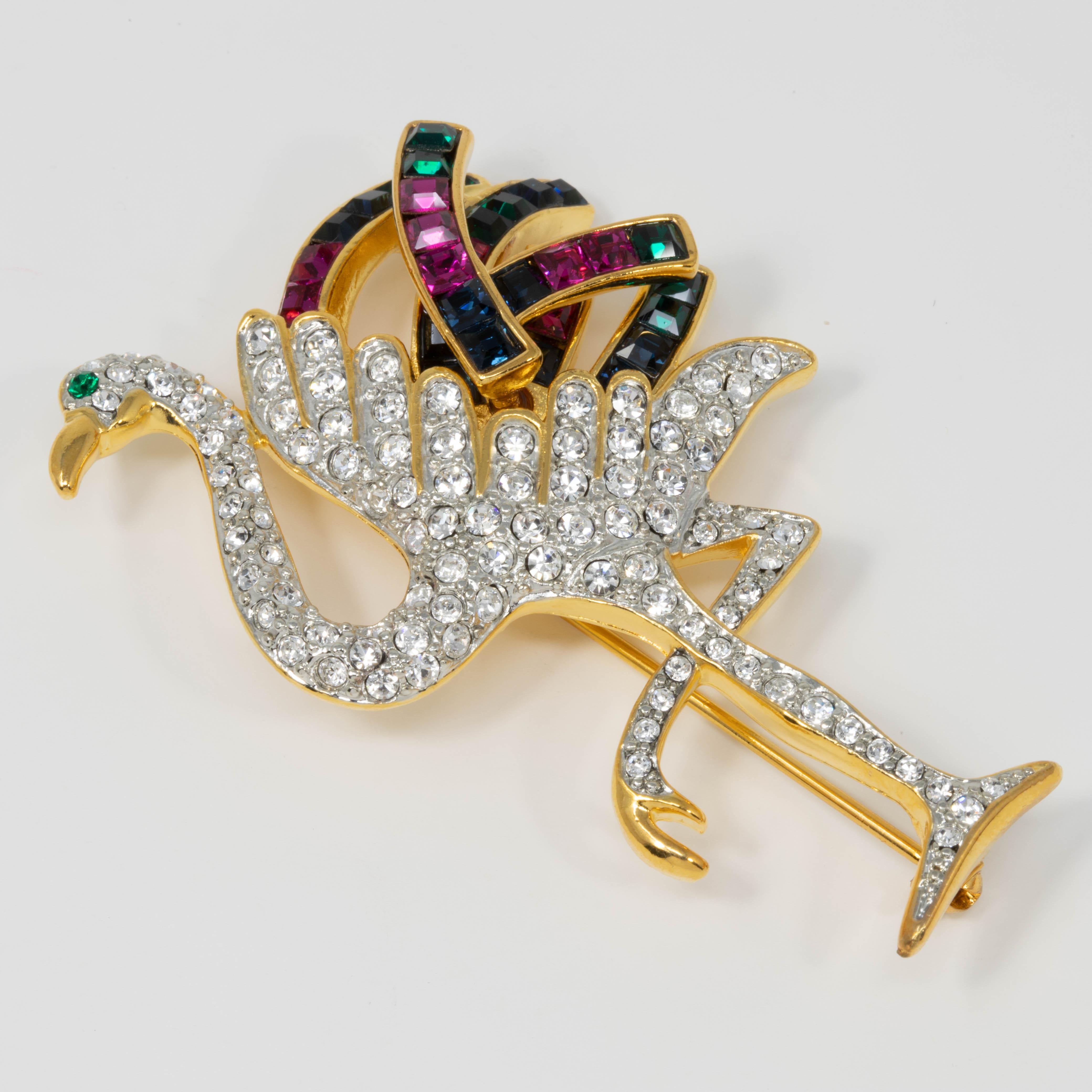 A golden flamingo, decorated with clear pave crystals and colorful jeweled tail feathers. Duchess of Windsor pin brooch by Kenneth Jay Lane.

Crystals: Amethyst, emerald, sapphire

Tags, Marks, Hallmarks: KJL