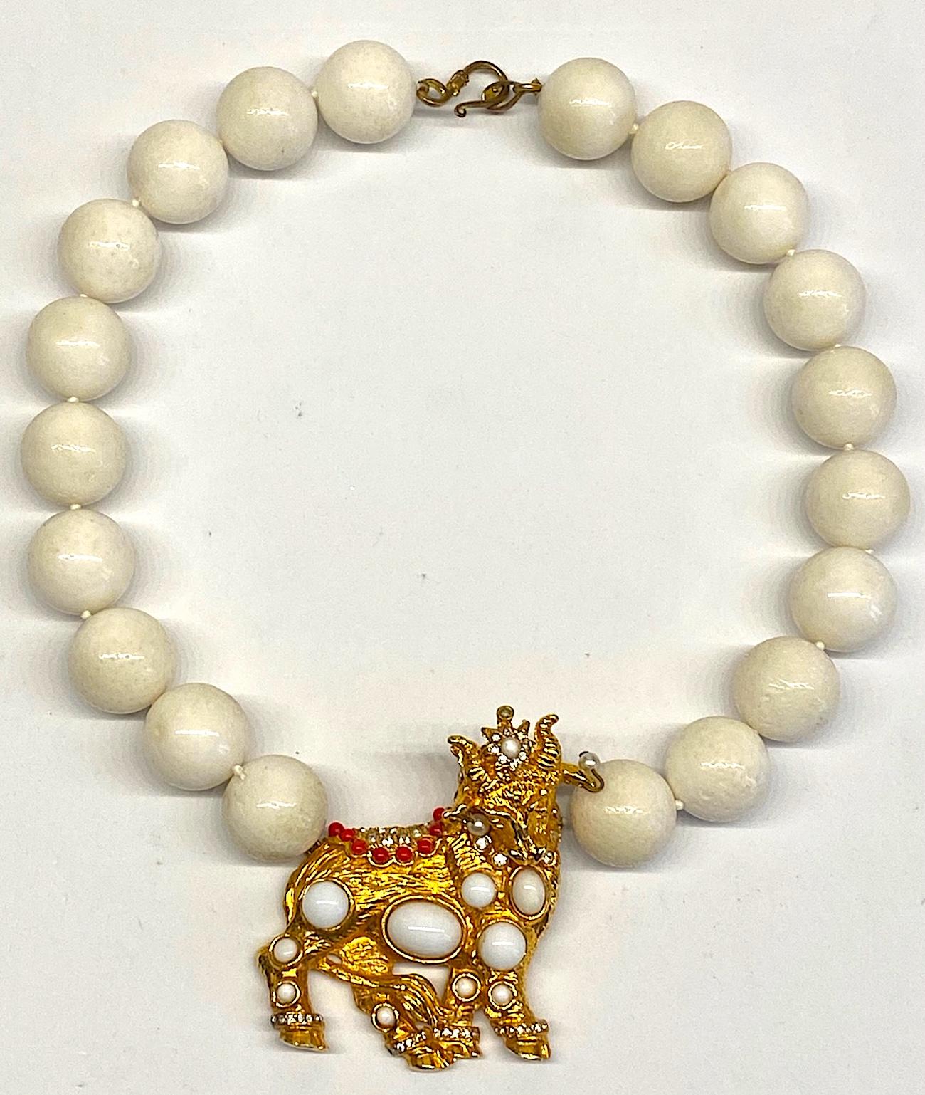 This is a very unusual and elegant custom made necklace from the 1980s. The off white beads are 20 mm in diameter and made of a hard stone. The brooch is a beautifully cast piece that was formerly a brooch. It is an unsigned version of Kenneth Jay