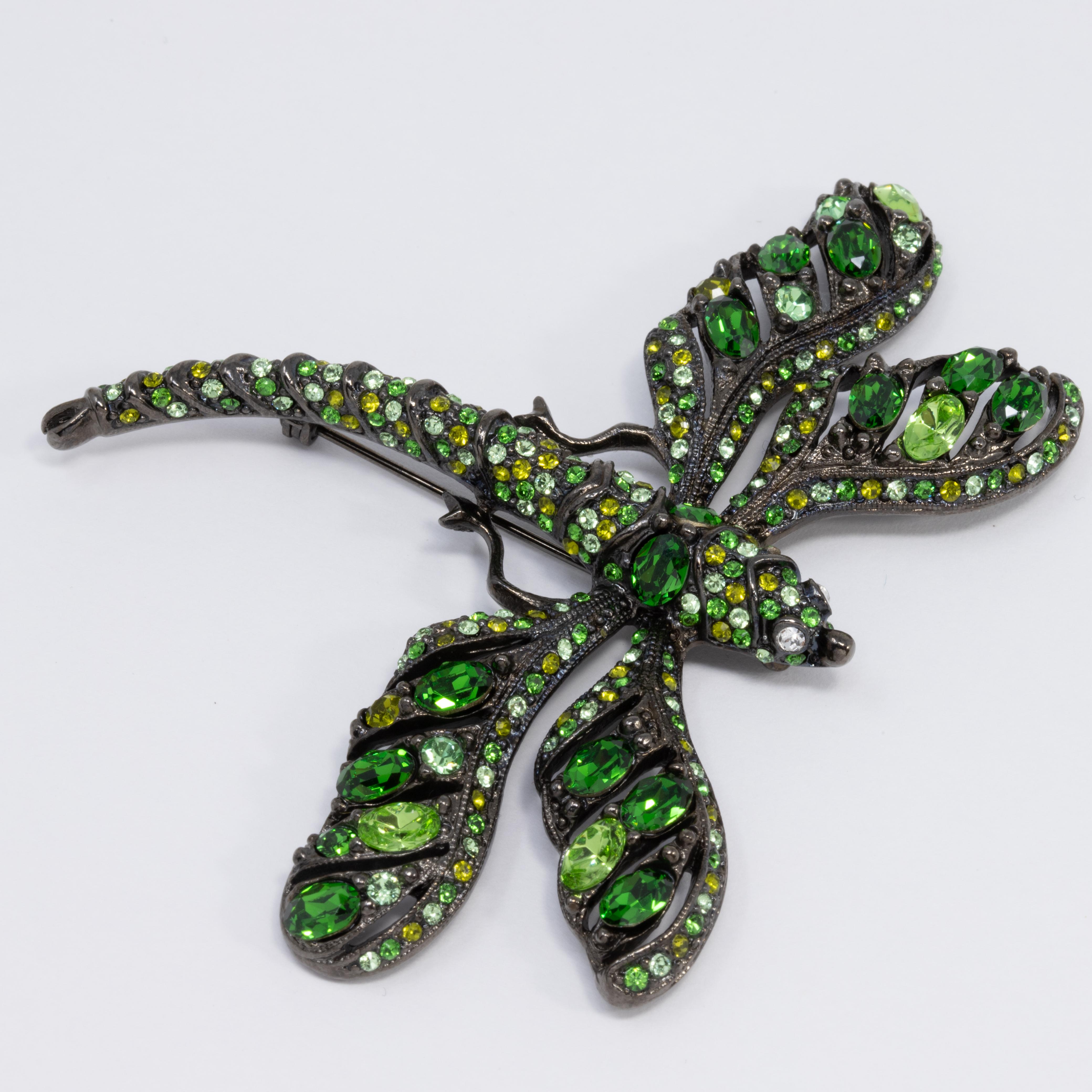 A stylish brooch by Kenneth Jay Lane! This dark gunmetal dragonfly is accented with dazzling green and yellow crystals.

Hallmarks: Kenneth © Lane
