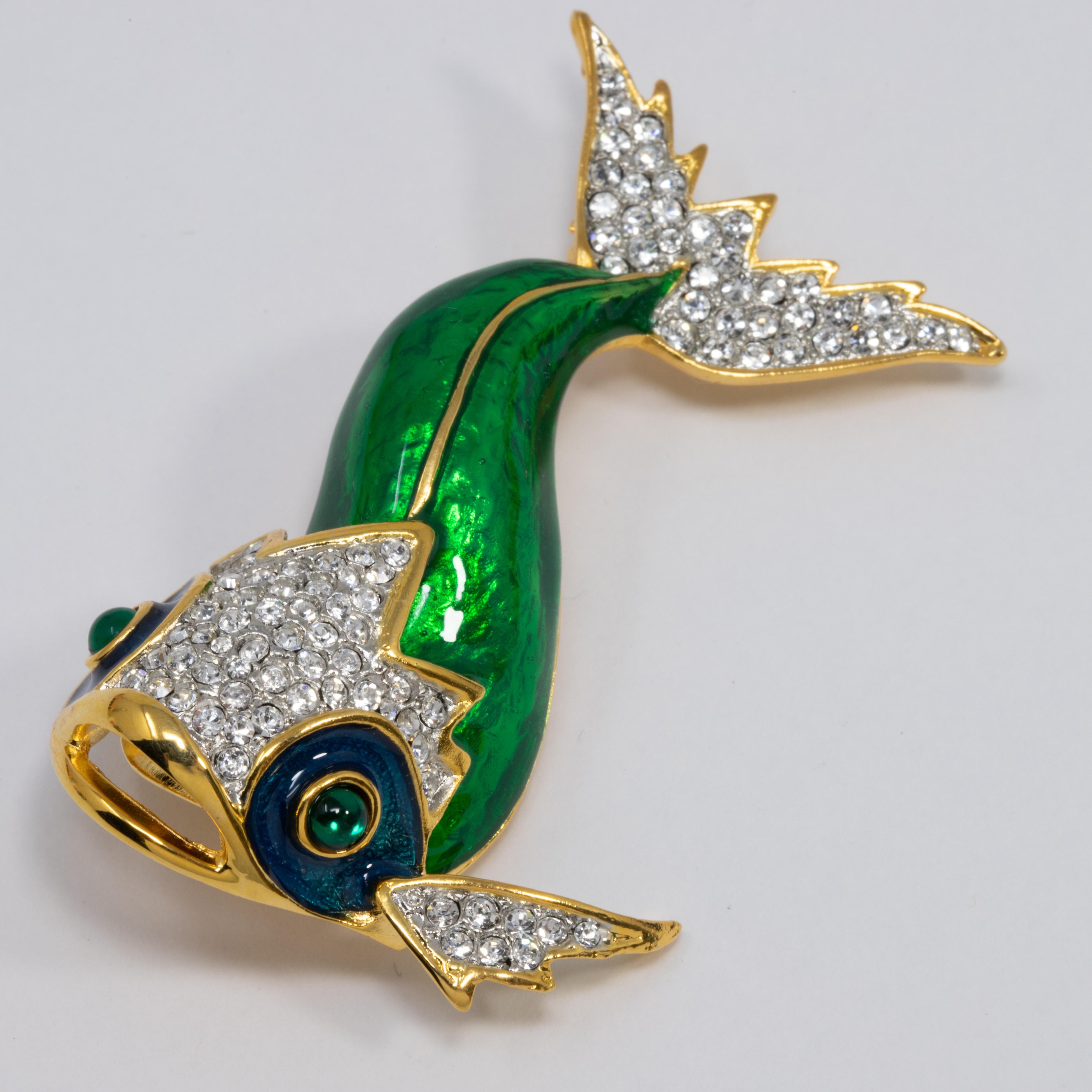 An embellished koi fish pin brooch by Kenneth Jay Lane. Features a painted green enamel body, accented with clear and green pave crystals. Set on gold plated metal.

Hallmarks: Kenneth Lane
