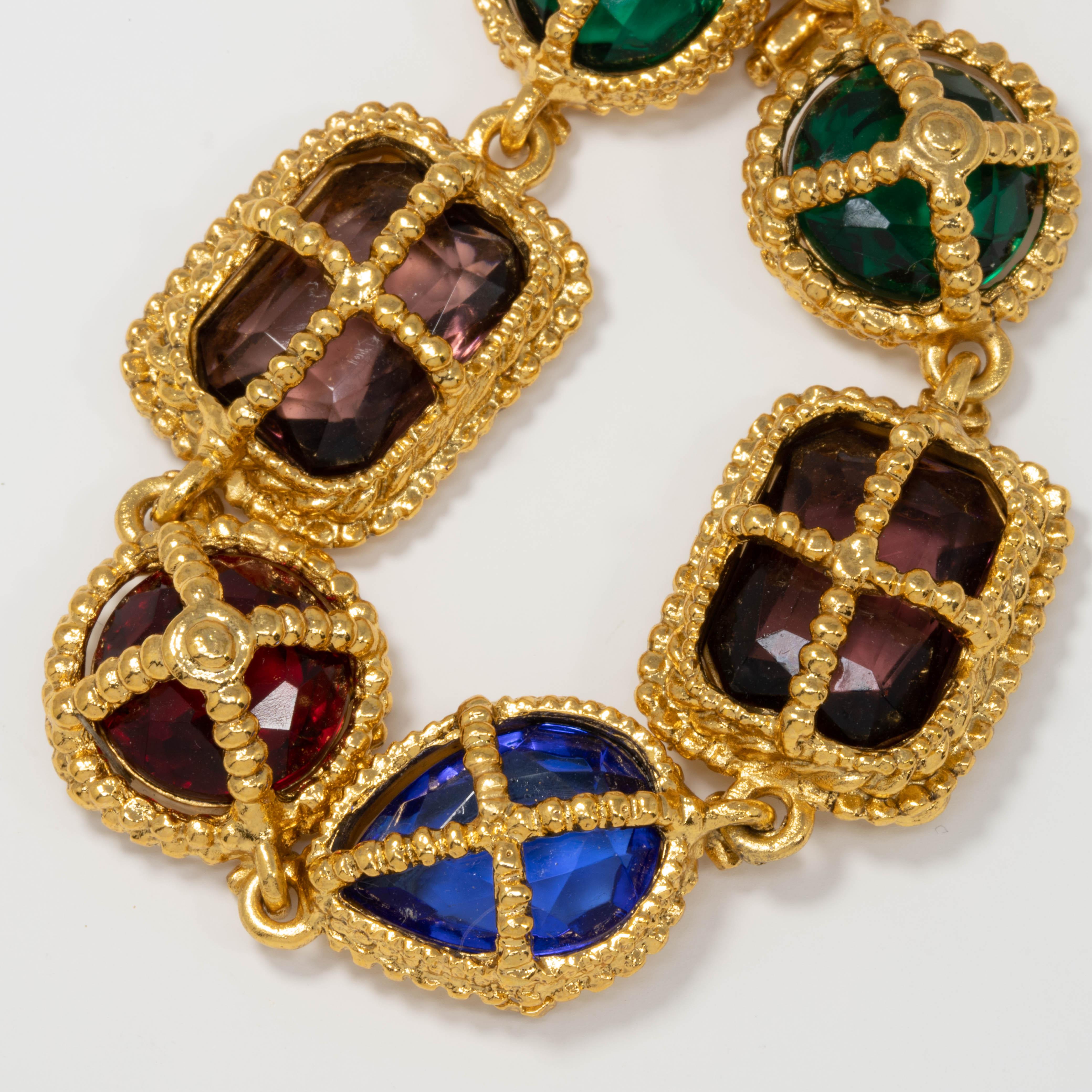 Big bold jewels sit in open-back gold-plated settings in this colorful retro-style Kenneth Jay Lane bracelet!

Crystals: Ruby, Sapphire, Amethyst, Emerald

Toggle clasp. Gold plated link bracelet.

Tags, Marks, Hallmarks: KJL