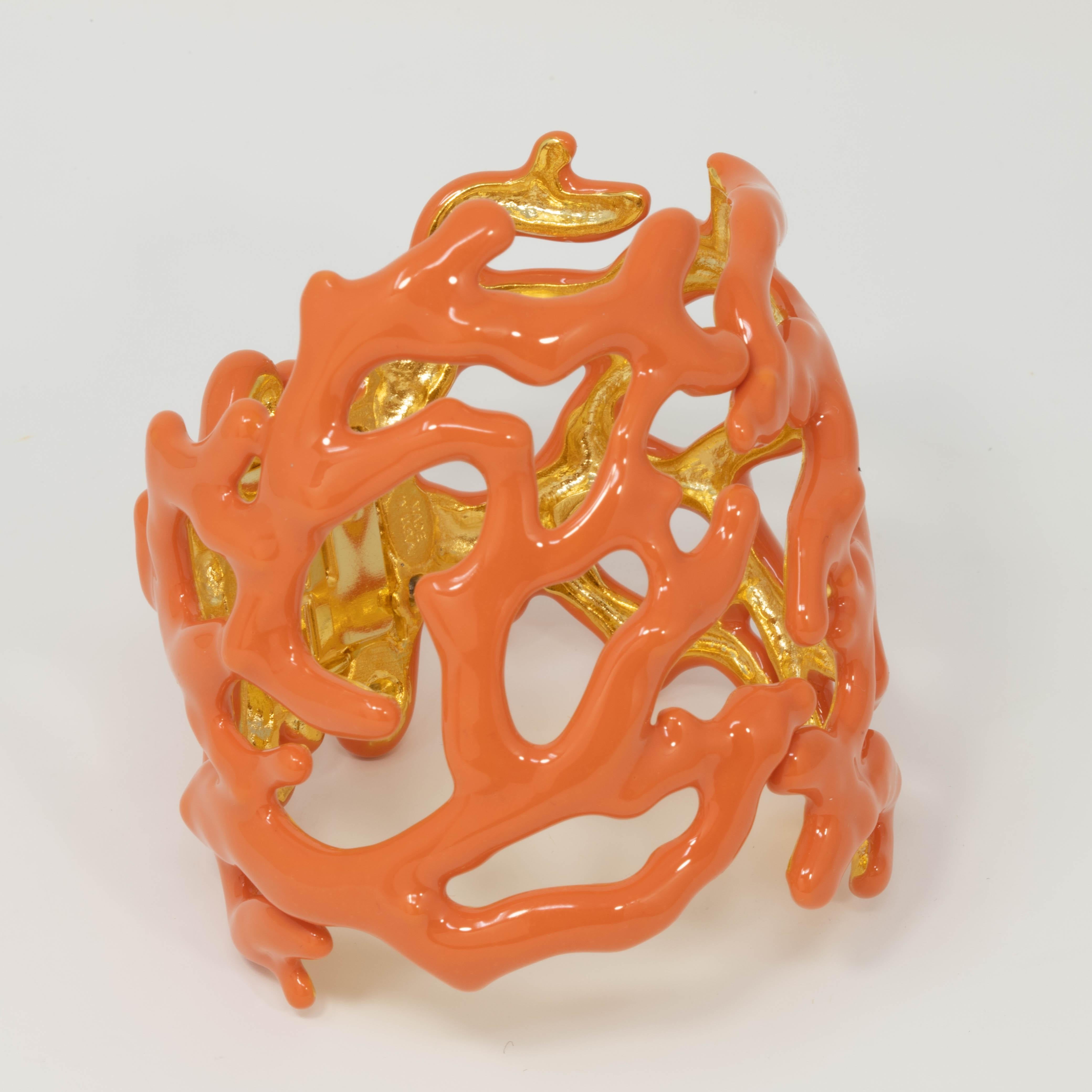 More beautiful than the oceans! This nautical Kenneth Jay Lane cuff bracelet features coral branches painted in a mellow-orange enamel. 

Set on gold plated metal setting. Hinged bangle.

Hallmarks: Kenneth Lane, Made in USA

Inner circumference: