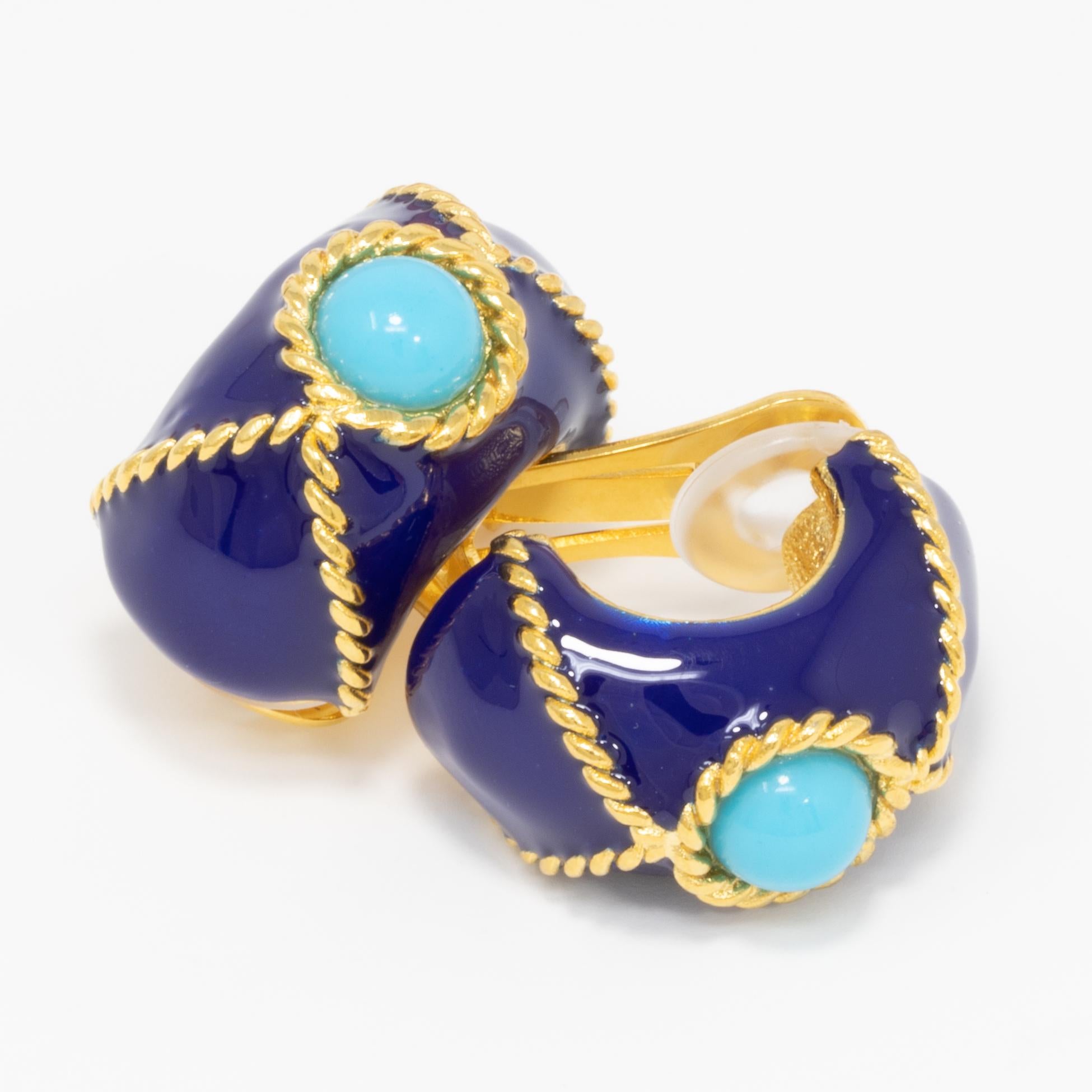 A pair of clip on earrings by Kenneth Jay Lane. Each gold-plated earrings is painted in blue, and decorated with a turquoise cabochon centerpiece and gold accents.

Tags, Marks, Hallmarks: KJL, Made in USA
