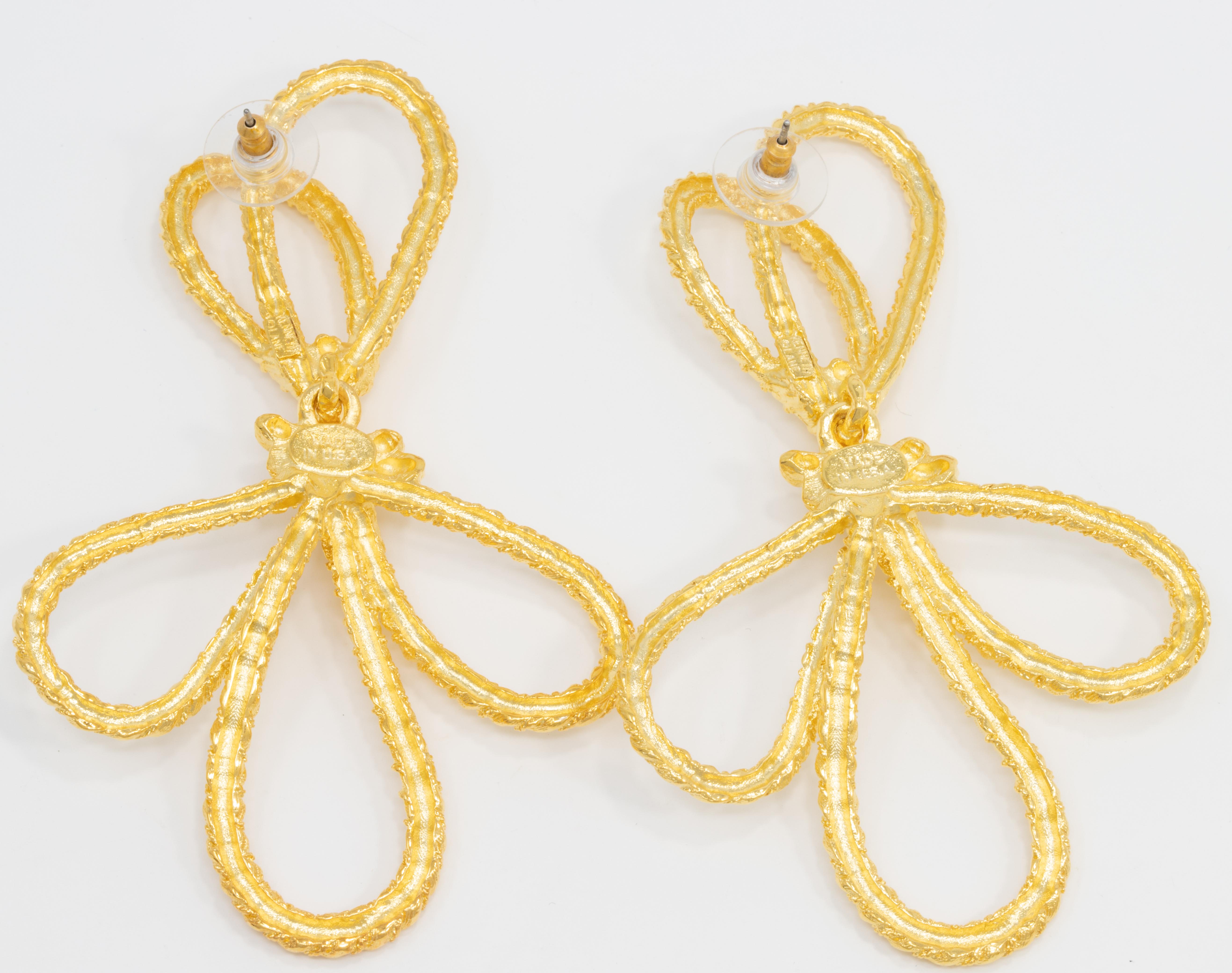 Bright gold-plated threads are tied into knotted bow links on these stylish Kenneth Jay Lane Necklace dangle earrings.

Tags, Marks, Hallmarks: Kenneth © Lane, Made in USA

Drop / dangle style with post backs