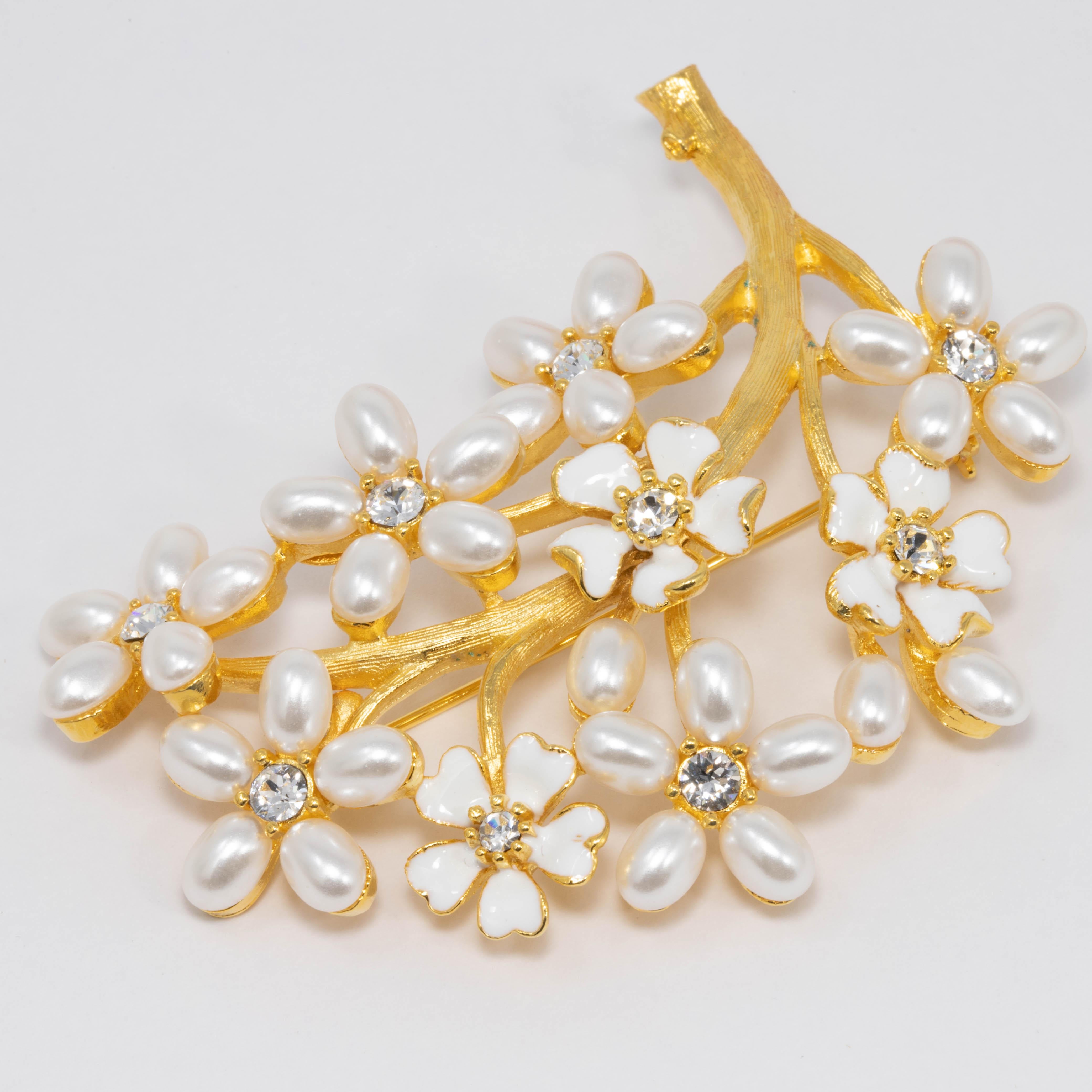 Elegance embodied in a gorgeous Kenneth Jay Lane pin brooch! Features golden branches, along with white flowers, with faux pearl and enamel petals, and sparkling crystal centers.

Gold-plated.

Tags, Marks, Hallmarks: Kenneth © Lane, Made in USA