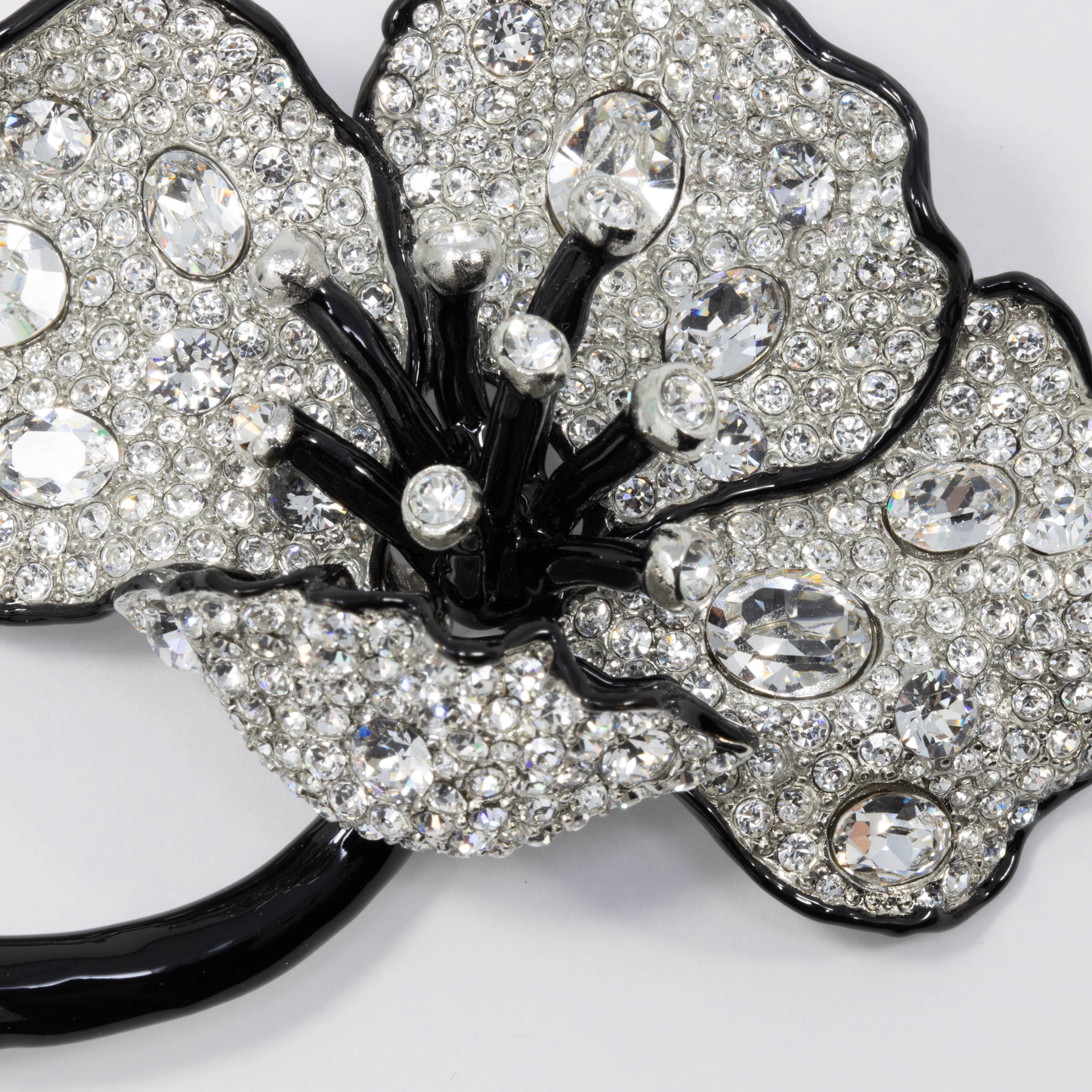 Exquisite poppy flower brooch by Kenneth Jay Lane. This pin brooch features a long black-enamel stem with sparkling pave-crystal petals, accented with a black enamel trim.
...

Clasp: Pin stem with safety clasp

Tags, Marks, Hallmarks: Kenneth © Lane