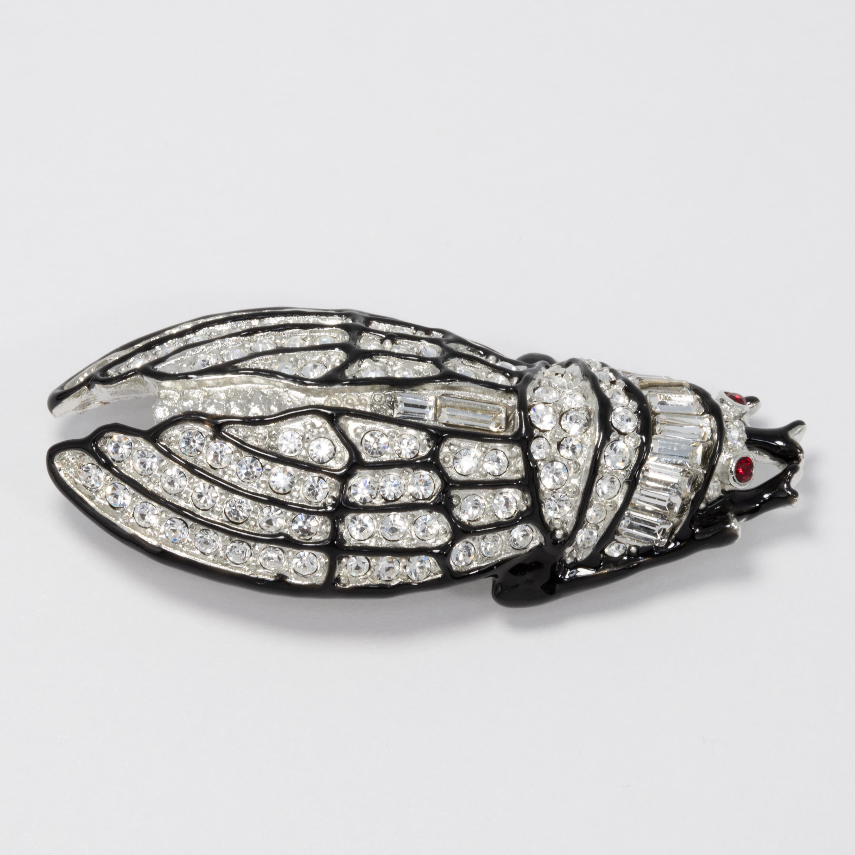 Pavé crystals illuminate this elegant cicada brooch that finishes your glamorous look.

Silver and crystal pavé
Black enamel highlights 
3 1/4