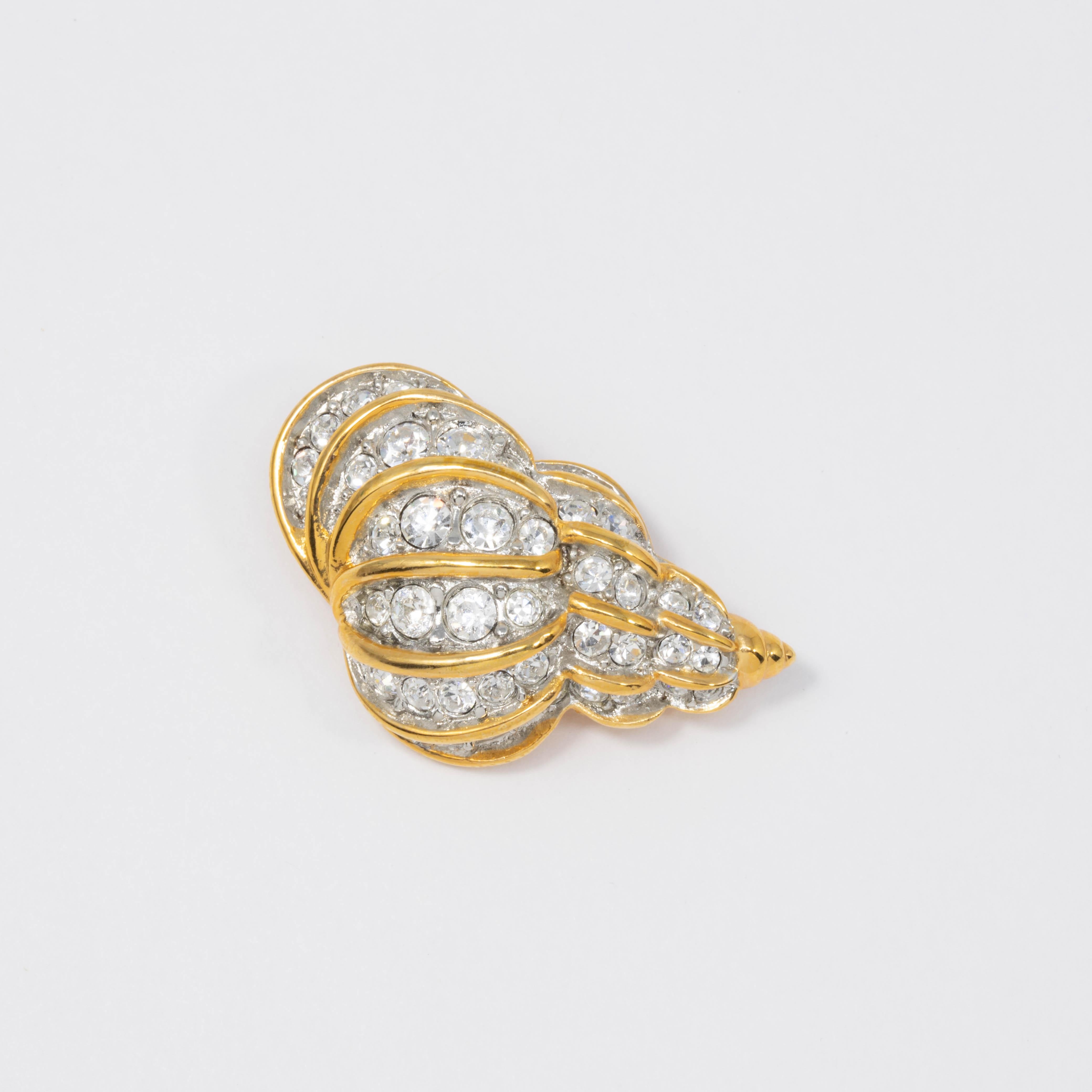 More beautiful than the oceans! A golden conch pin brooch by Kenneth Jay Lane covered with sparkling clear pave crystals.

Gold plated.

Tags, Marks, Hallmarks: KJL, Made in USA