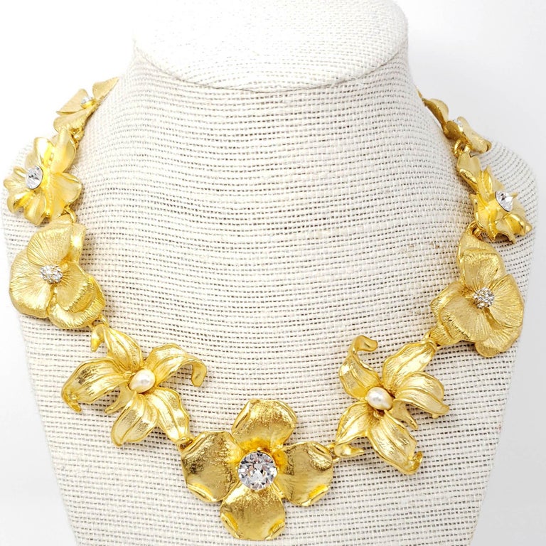 Glowing feminine beauty! This satin gold flower collar necklace with crystal and white faux pearl centers elevates any look with sparkling, blooming flowers cast in a golden gleam.

Length 14.5 in / 37 cm plus 3.25 in / 8.5 cm extension
