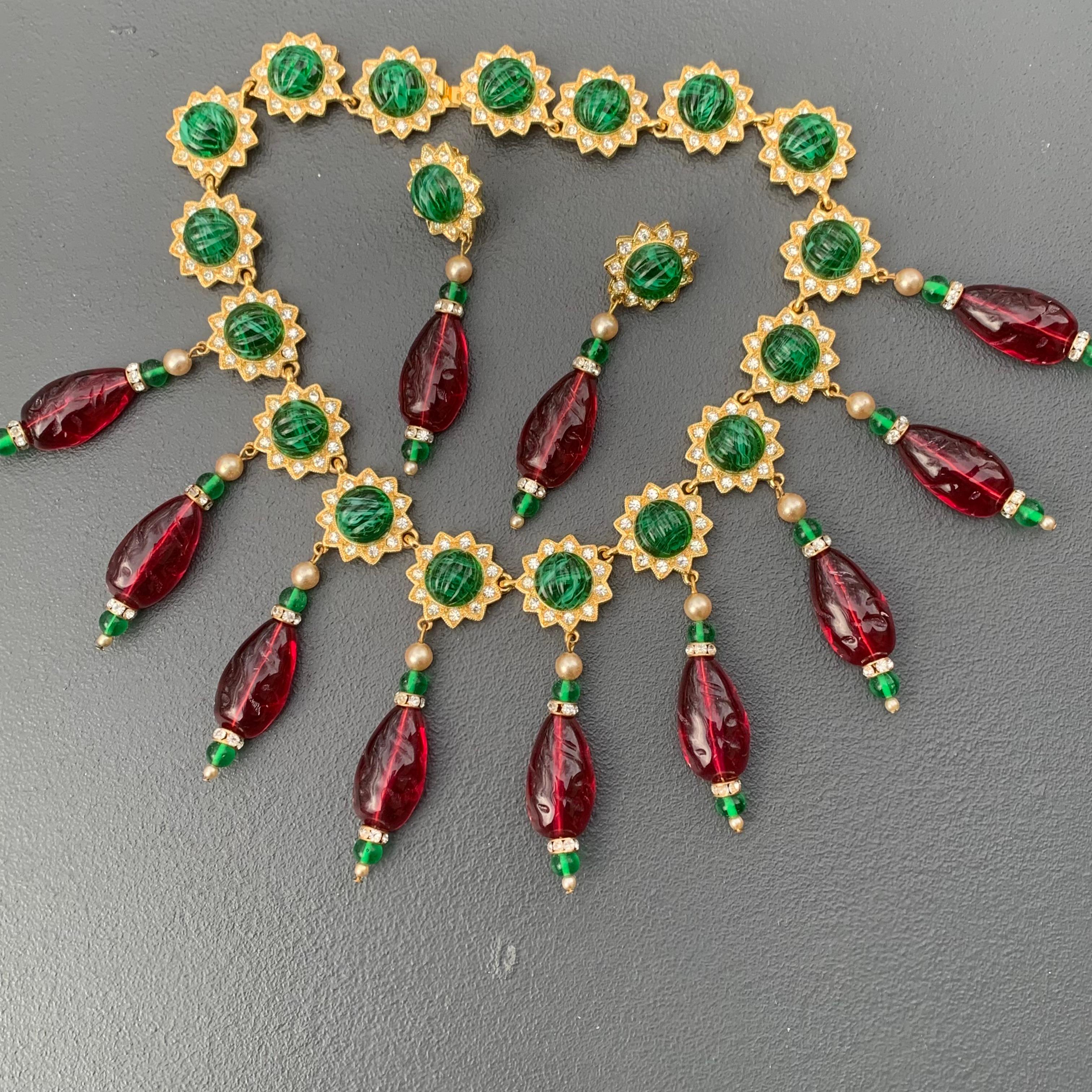 Fit for Queen is Signed Kenneth Lane Statement necklace and matching clip-on earrings  featuring linked gold plated flowers with clear crystals and ribbed emerald green glass cabs center . Front flowers have ruby colored resin dangles , 
Necklace