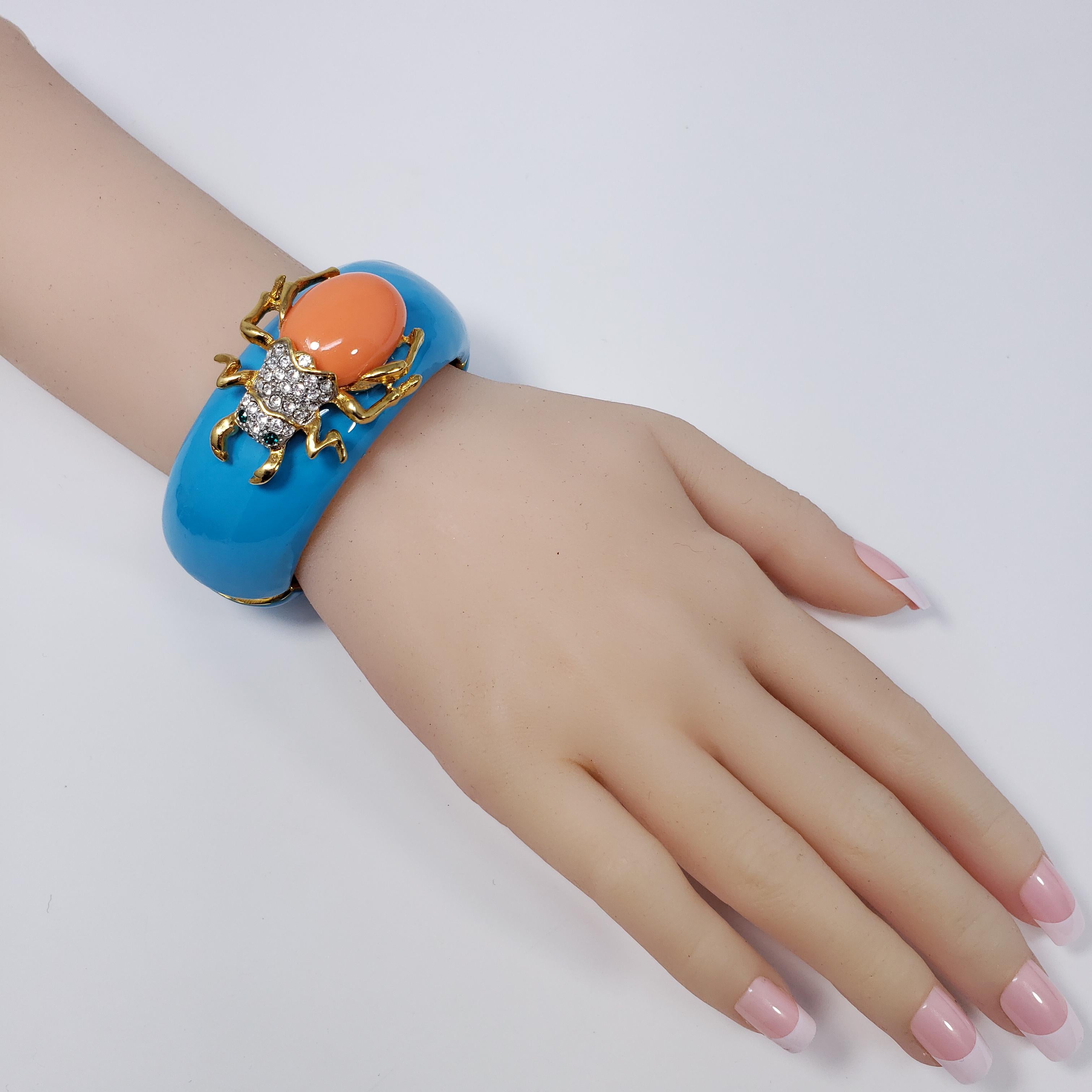 A colorful bracelet by Kenneth Jay Lane! Features a turquoise enamel face accented with a pave-crystal scarab with a resin back.

This bracelet has white enamel marking on one side, a small imperfection.

Inner circumference: 16 cm
Diameter at