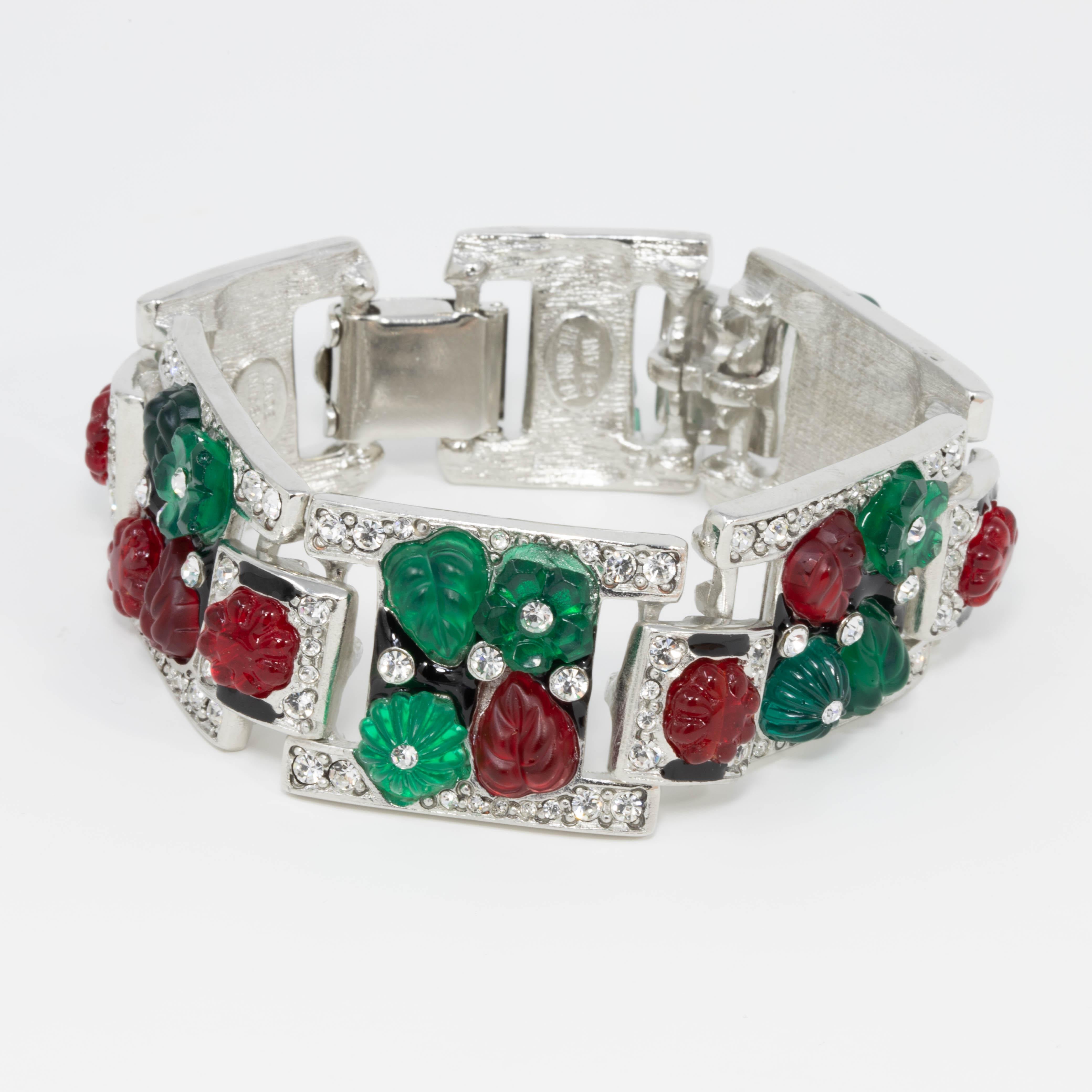 Colorful link bracelet by Kenneth Jay Lane. Red and green opaque tutti frutti fruit and leaf motifs accented with sparkling crystals crystals. Set on rhodium plating. Fold-over clasp closure.

Hallmarks: Kenneth Lane, Made in USA

Length: 7.25 in /
