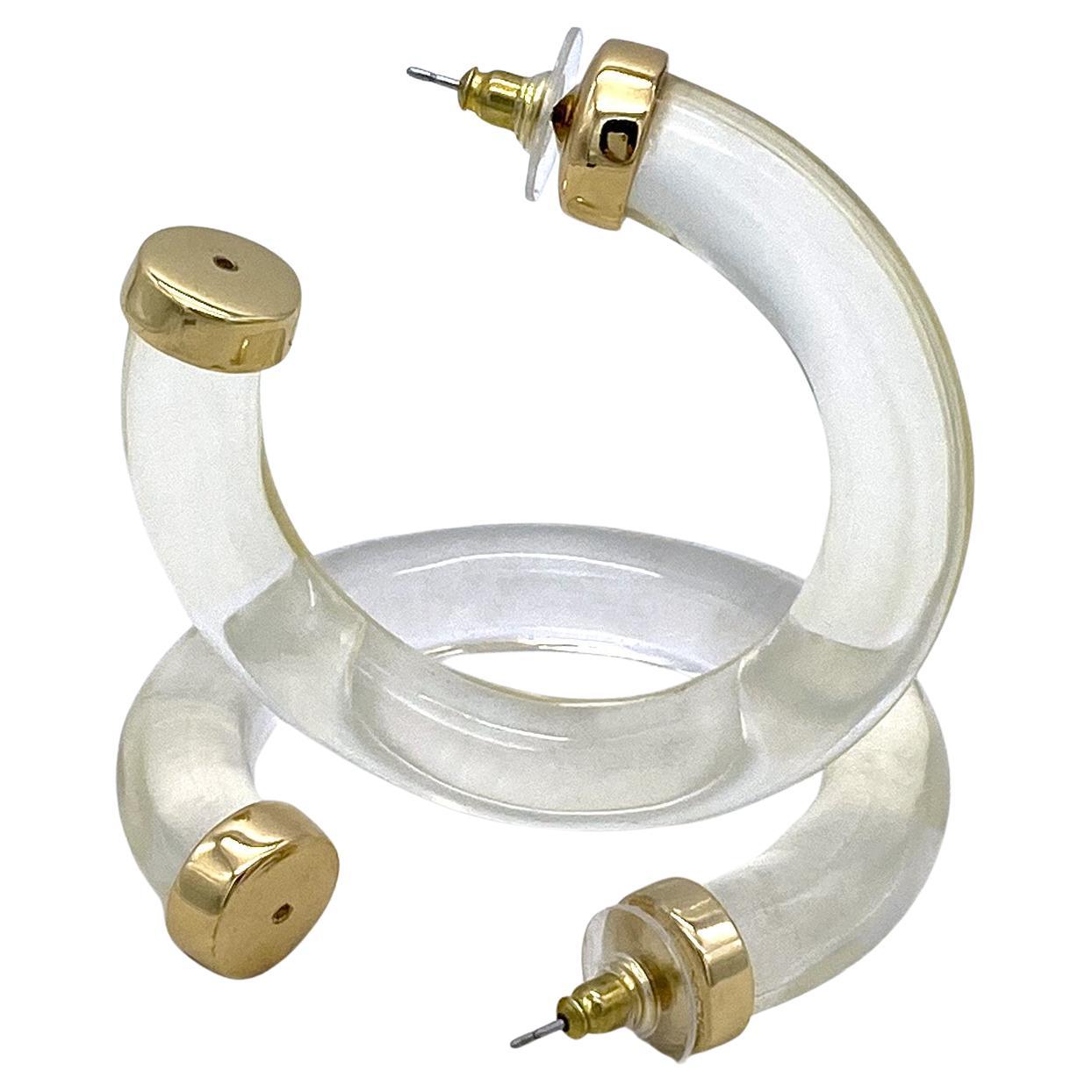 This pair of Kenneth Jay Lane clear lucite hoop post earrings is in great condition Like new! The KJL is stamped on gold plate caps. These 2.5 inch large hoop earrings were typical for late 1970s fashion.

Our vintage jewelry collection and original