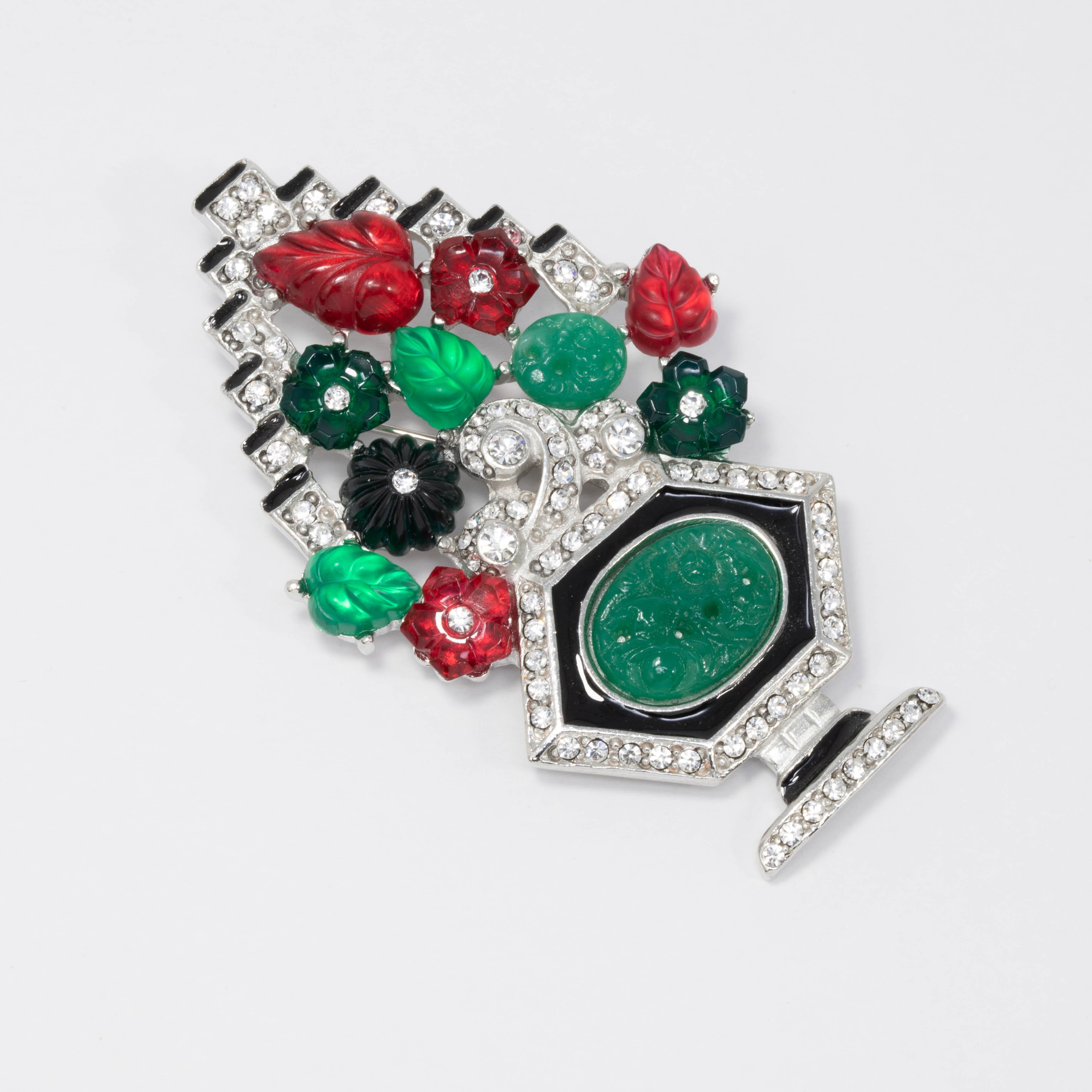Colorful tutti-frutti style art deco brooch by Kenneth Lane. Features bright green and red flower and leaf motifs accented with clear crystals and black enamel. Rhodium-plated metal setting.

Pair with the Kenneth Jay Lane Tutti Frutti art deco