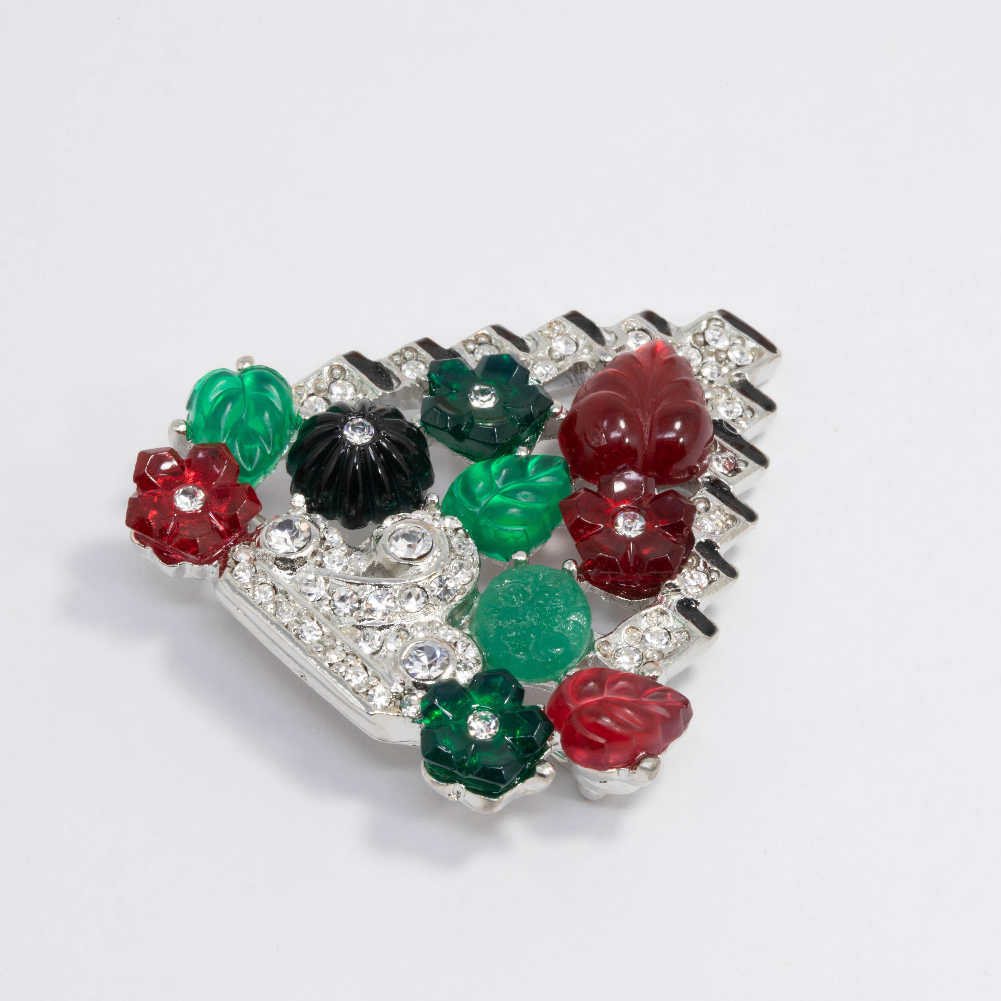Colorful tutti-frutti style art deco brooch by Kenneth Lane. Features bright green and red flower and leaf motifs accented with clear crystals and black enamel. Rhodium-plated metal setting.

Pair with the Kenneth Jay Lane Tutti Frutti art deco