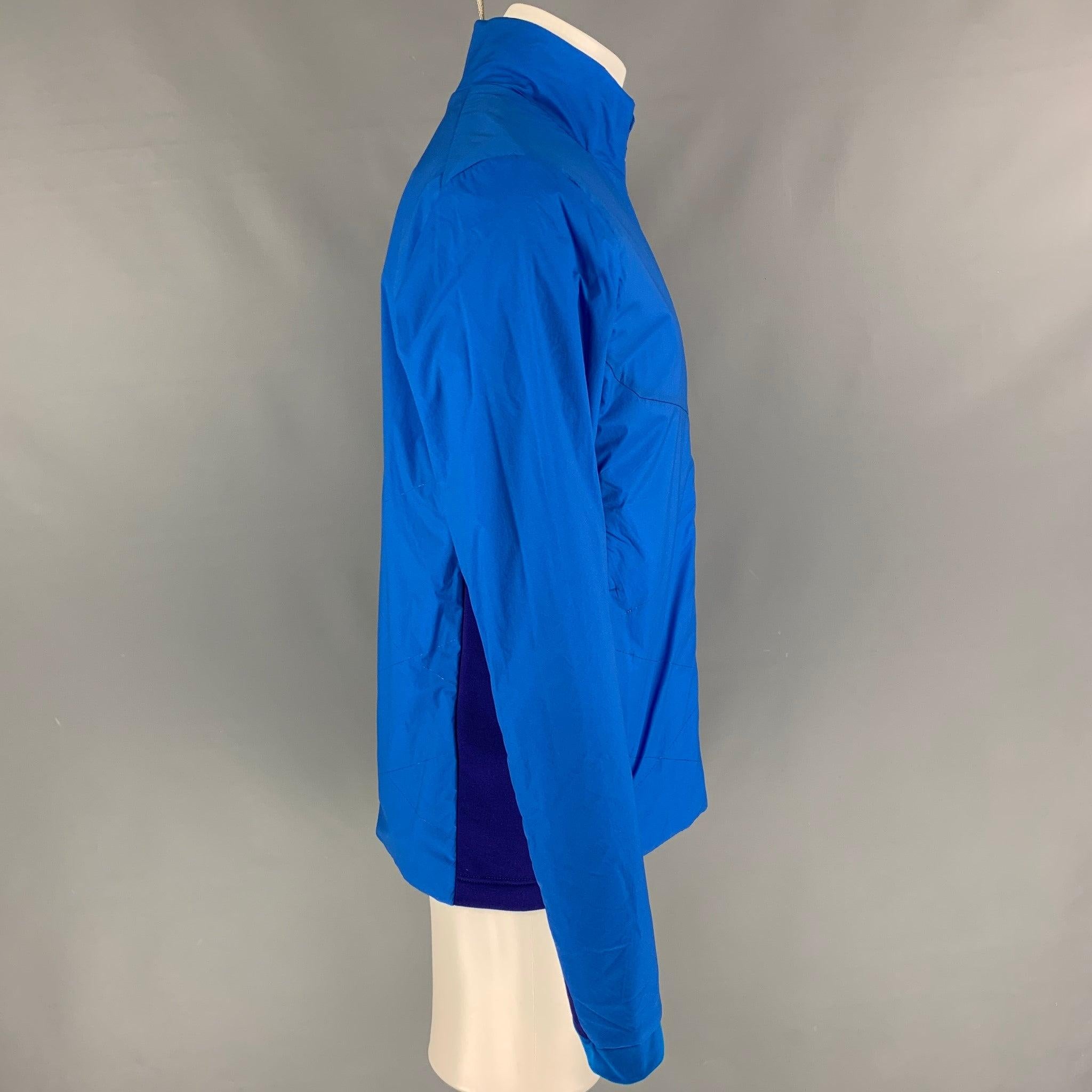 KJUS jacket comes in a royal blue & purple two toned nylon blend featuring a high collar, slit pockets, and a zip up closure.
New With Tags.
 

Marked:   M  

Measurements: 
 
Shoulder: 19 inches  Chest: 42 inches  Sleeve: 28 inches  Length: 29