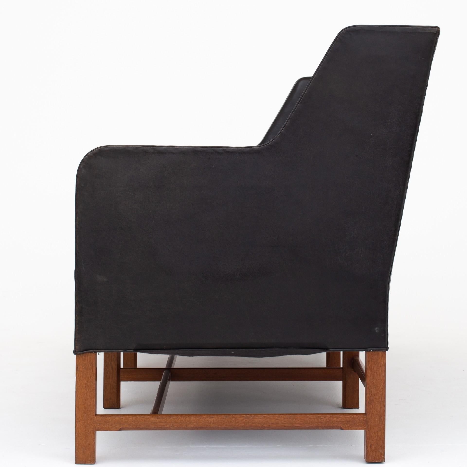 3-seat sofa model 5011 in black leather and mahogany base. Maker Rud Rasmussen.