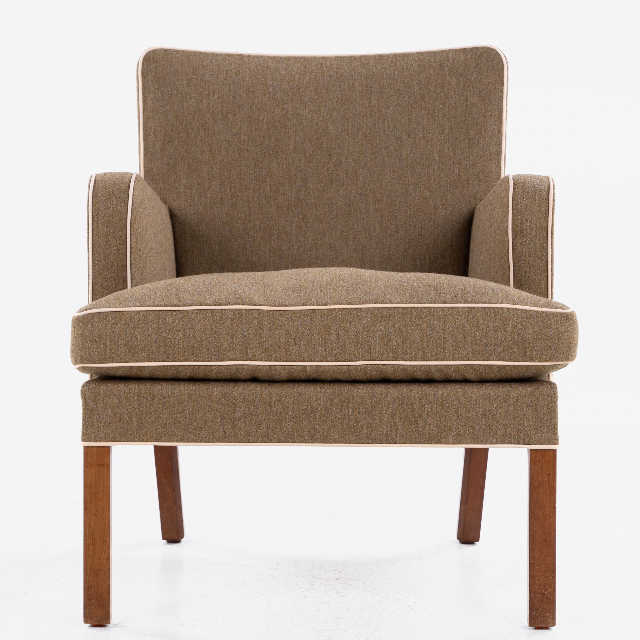 Kaare Klint model KK 5313 lounge chair with mahogany legs and newly upholstered textile with a leather piping.