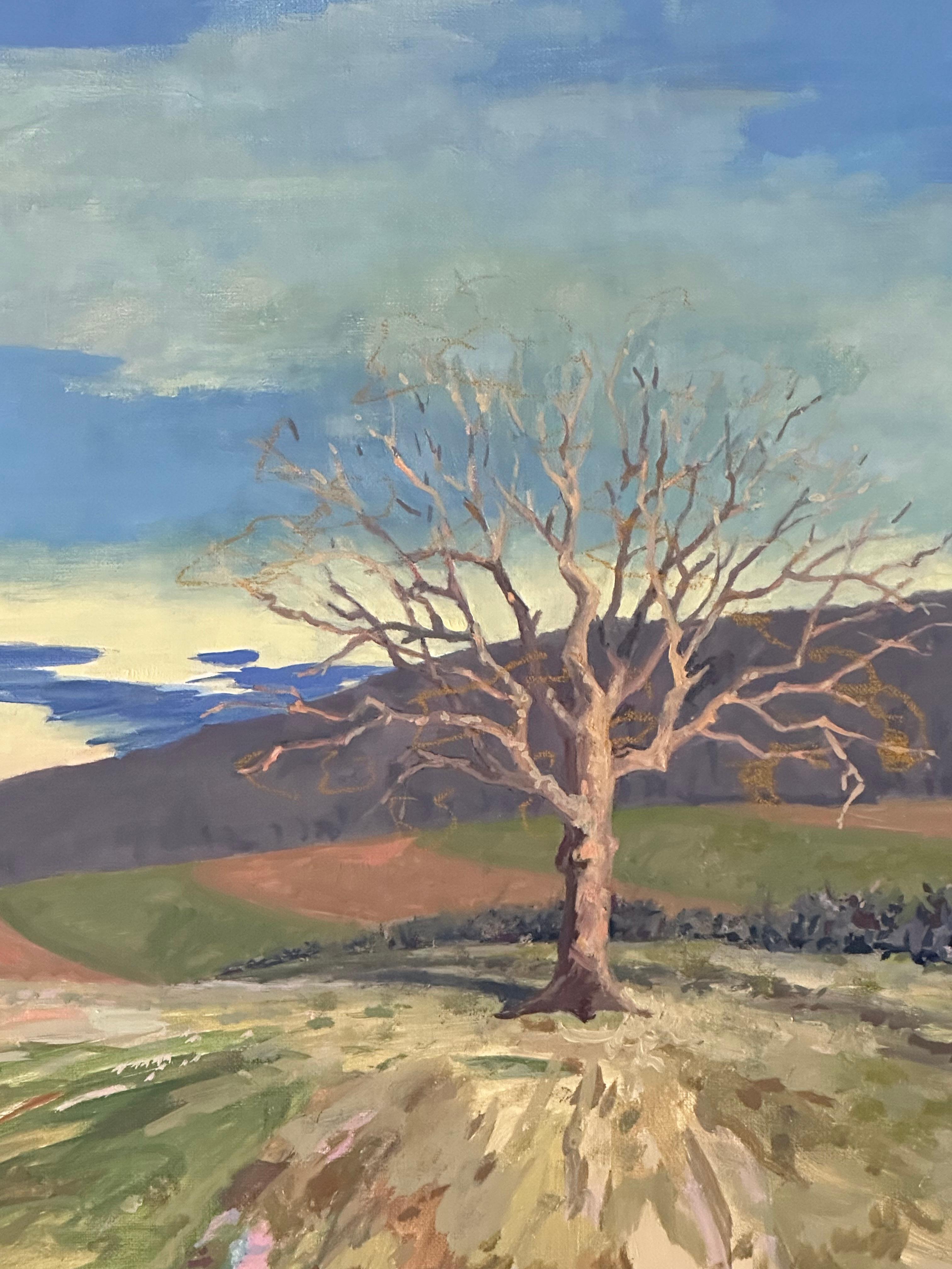 Soft clouds float in a pale blue sky with hints of luminous pale yellow towards the horizon, over an idyllic rural landscape with rolling hills and a single tree, barren of leaves in early spring. Signed, dated and titled on verso.

KK Kozik is a