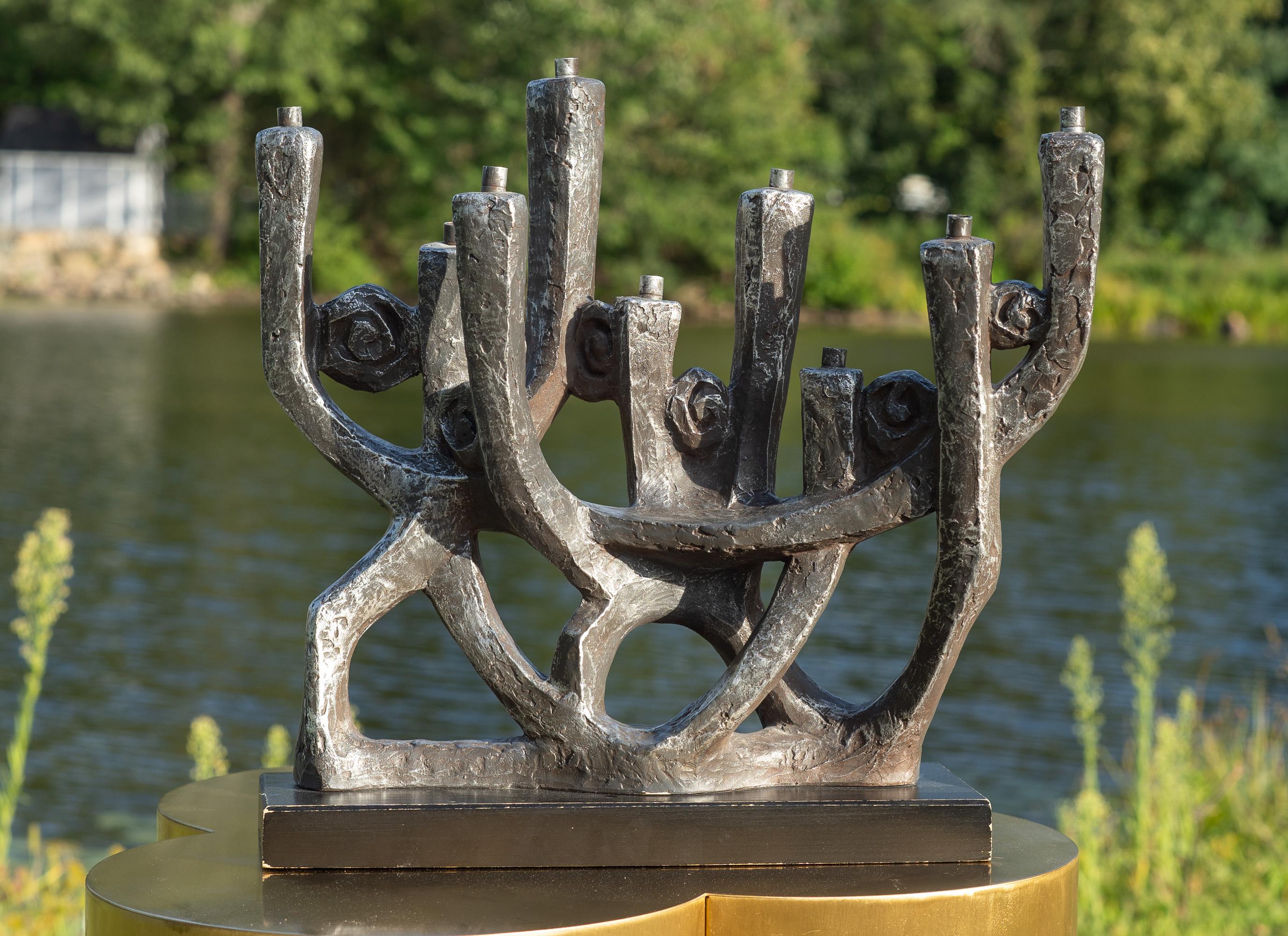 Designed by Klara Sever for Austin Productions, this menorah is shaped of plaster, then painted in a cool gunmetal color and set on a black painted wooden base. A fun modernist take on an ancient theme. It looks great in any mid-century home, and