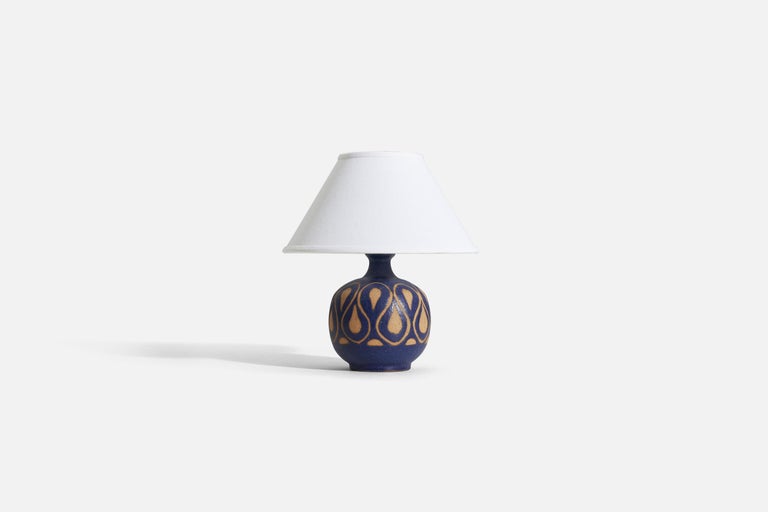 A blue glazed stoneware table lamp produced by Klase Höganäs, Sweden, 1960s.

Sold without lampshade. 
Dimensions of Lamp (inches) : 10.5 x 6.25 x 6.25 (H x W x D)
Dimensions Shade (inches) : 5 x 12.25 x 7.25 (T x B x H)
Dimension of Lamp with shade
