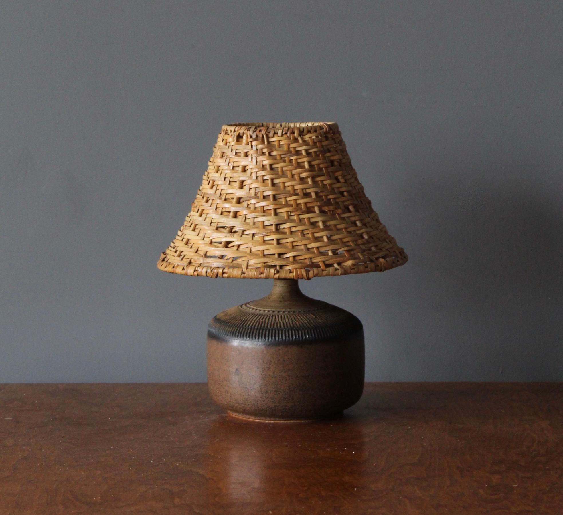 A table lamp by Klase Höganäs. In stoneware with simple incised decor. Signed. 

Dimensions stated include lampshade. Near identical vintage rattan lampshade of illustrated model can be included upon request.